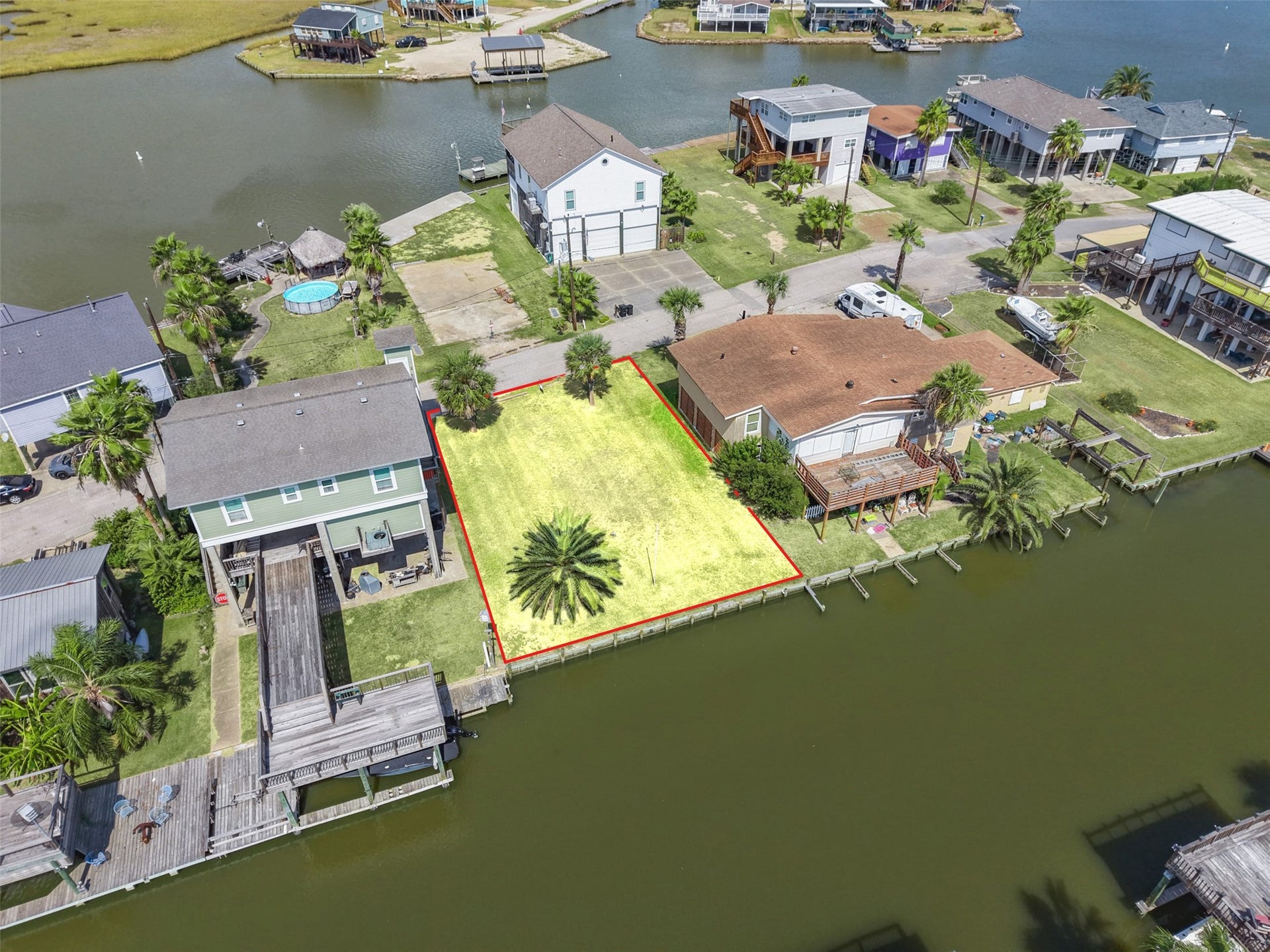 65 Lakeside Drive, Hitchcock, TX 77563 A little farther down the canal. The lot is cleared, with newer construction on both sides, and ready for a build in the same raised style you see all around it.