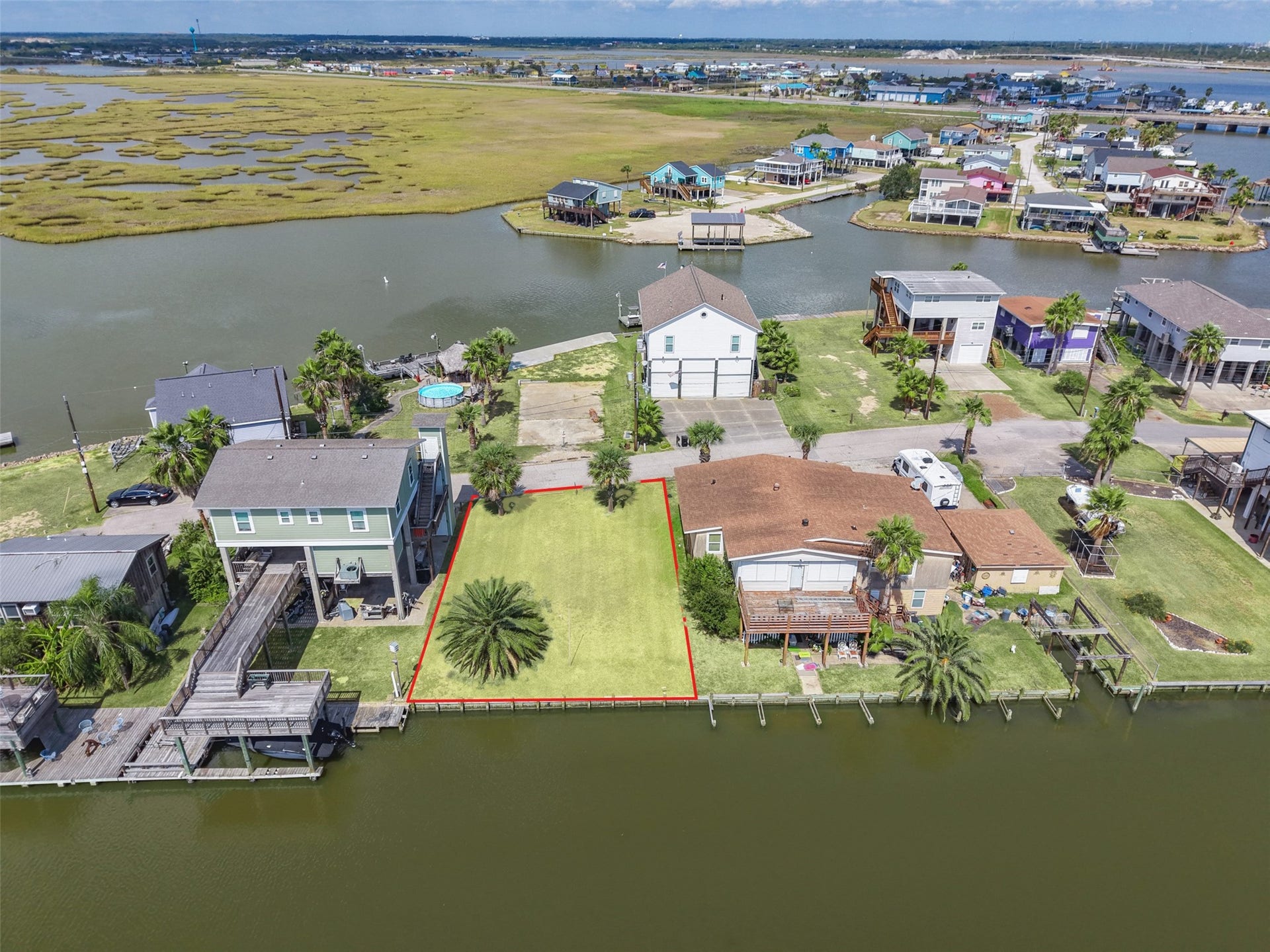 65 Lakeside Drive, Hitchcock, TX 77563 From out over the canal looking back at the lot. Wood bulkhead across the back, a home on each side, and the water right at the back door of your future vacation home!