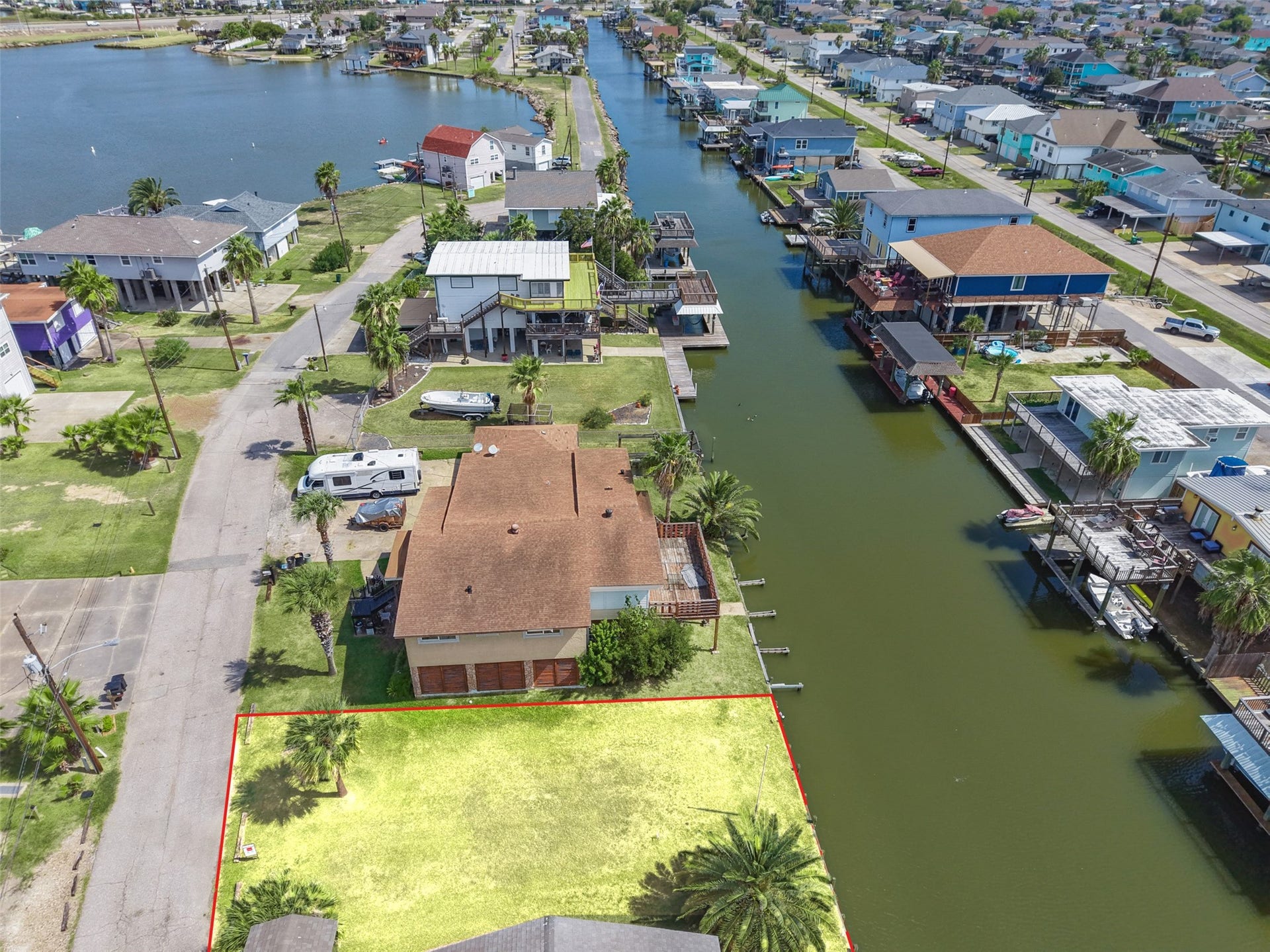65 Lakeside Drive, Hitchcock, TX 77563 Along the canal looking down Lakeside Drive, with the lot at the bottom of the frame. The canal runs out toward the bay, so open water is close. Harborwalk Bait Shop is about 2.6 miles away.