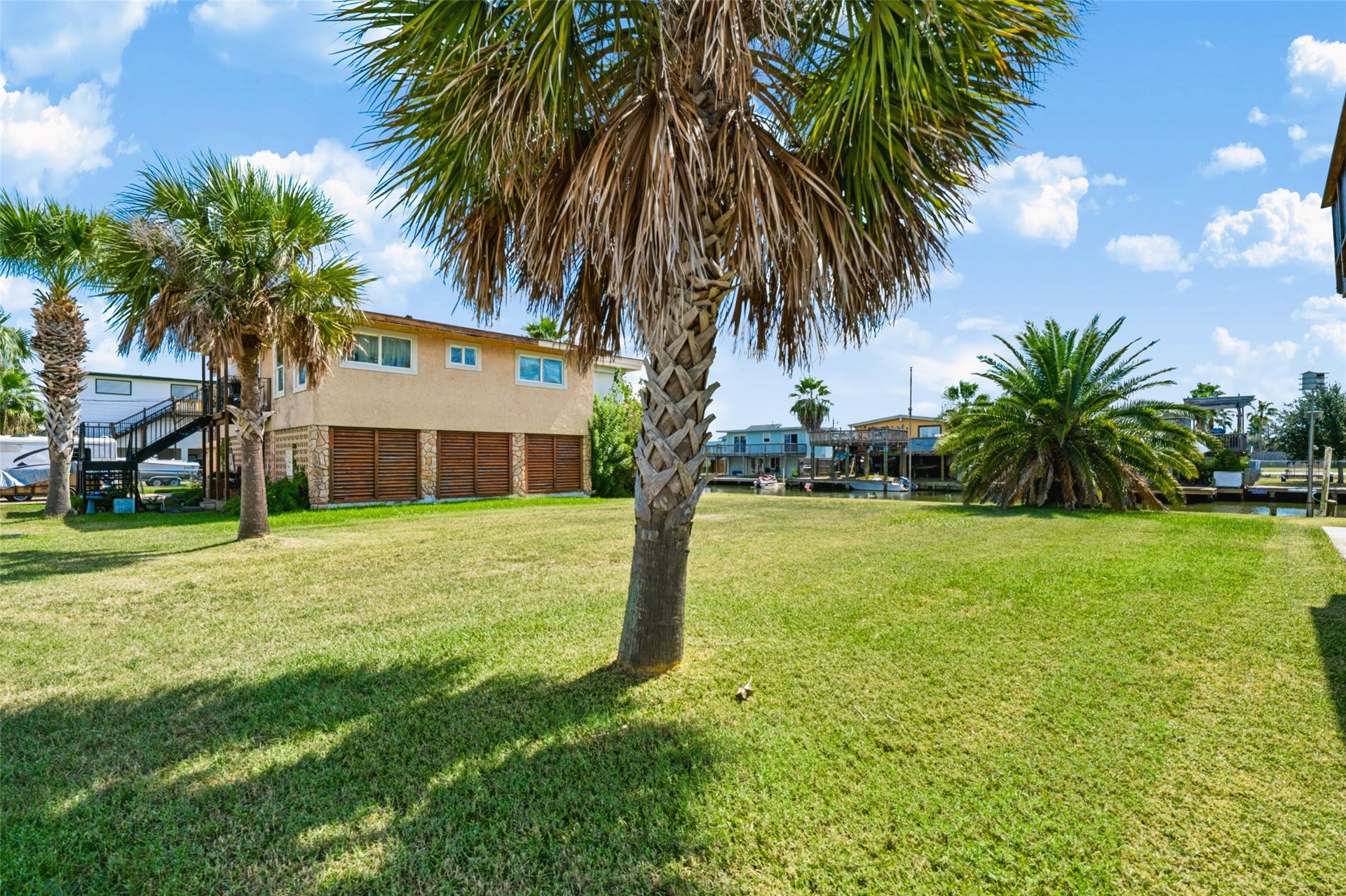 65 Lakeside Drive, Hitchcock, TX 77563 On the ground now! Two tall Sabal palms stand at the front of the lot and a full Canary Island date palm anchors the back, a nice head start on landscaping. The rest is cleared grass all the way to the water. Taxes on the lot were $1,419 in 2026.