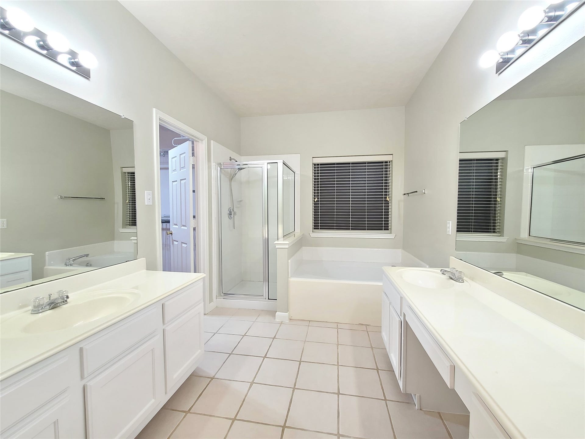 Spacious primary bathroom with separate tub and shower, and double sinks.
