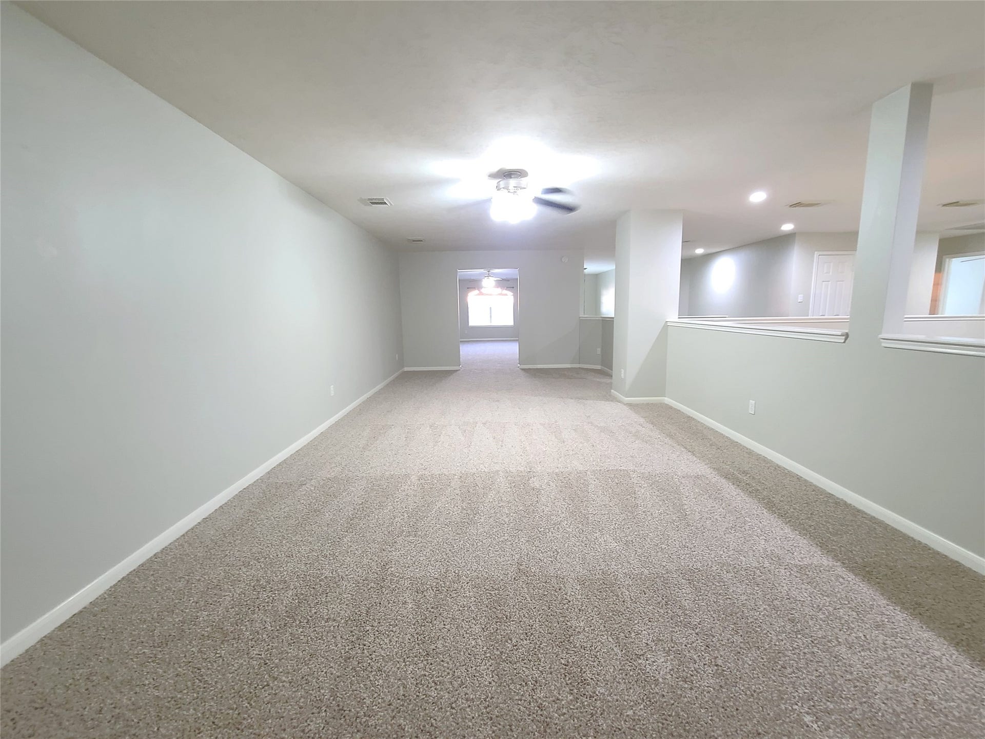 Large open gameroom overlooks the living room and leads to the entertainment/theater room