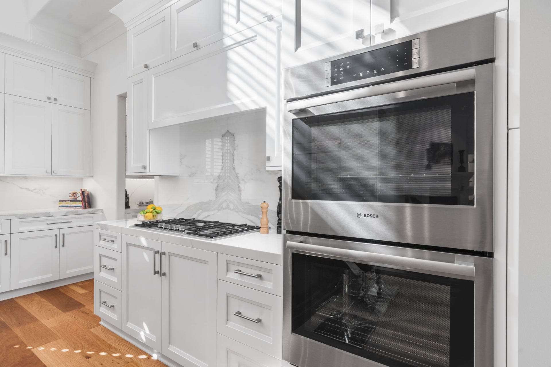 39 N Palmiera Circle, The Woodlands, TX 77382 Book matched quartz acts as the focal point behind the cooking surface that is outfitted into Wood-Mode cabinets.