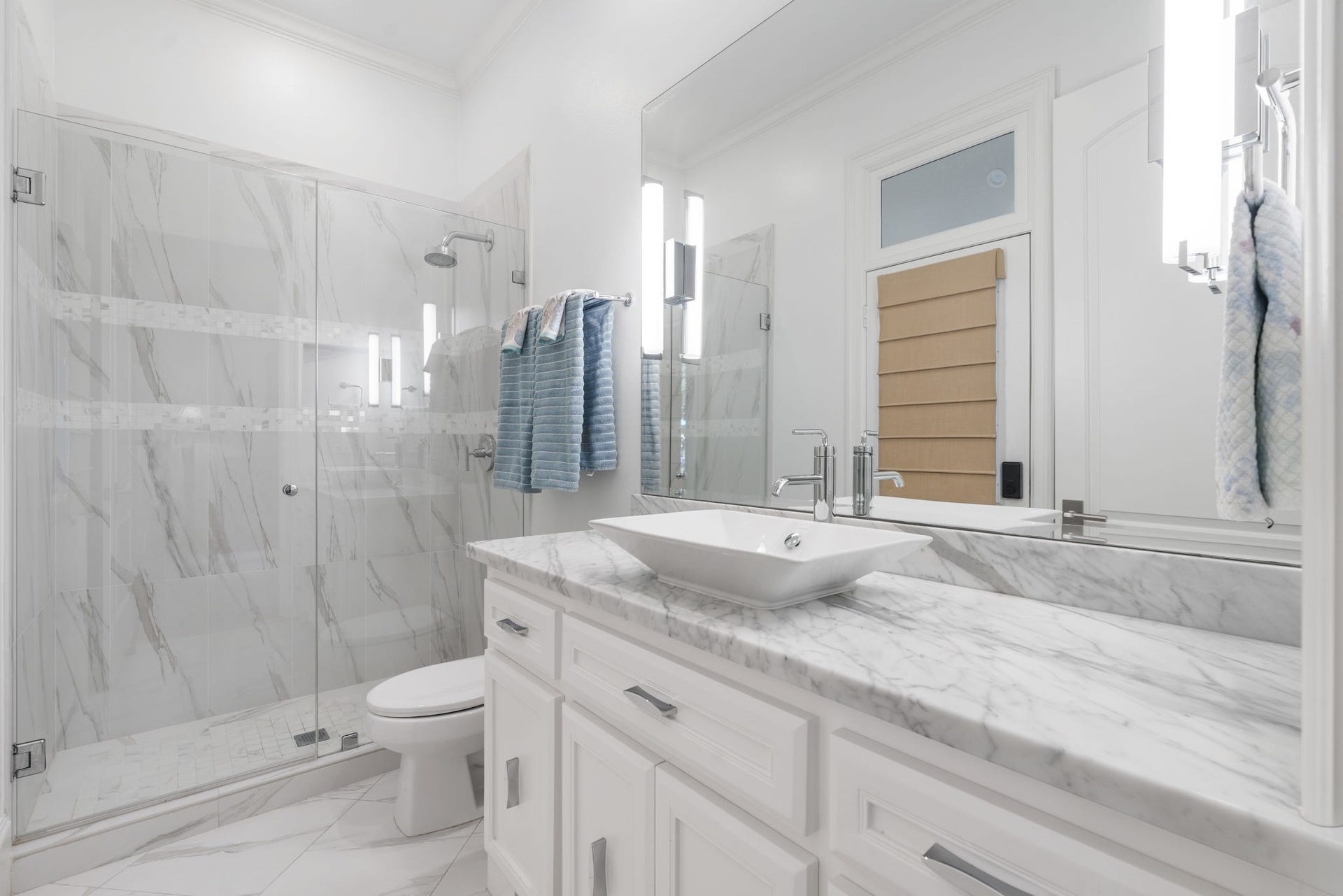 39 N Palmiera Circle, The Woodlands, TX 77382 Boasting beautiful updates of its own, the guest bath features a large walk-in shower, new marble counter, vessel sink and generous storage.