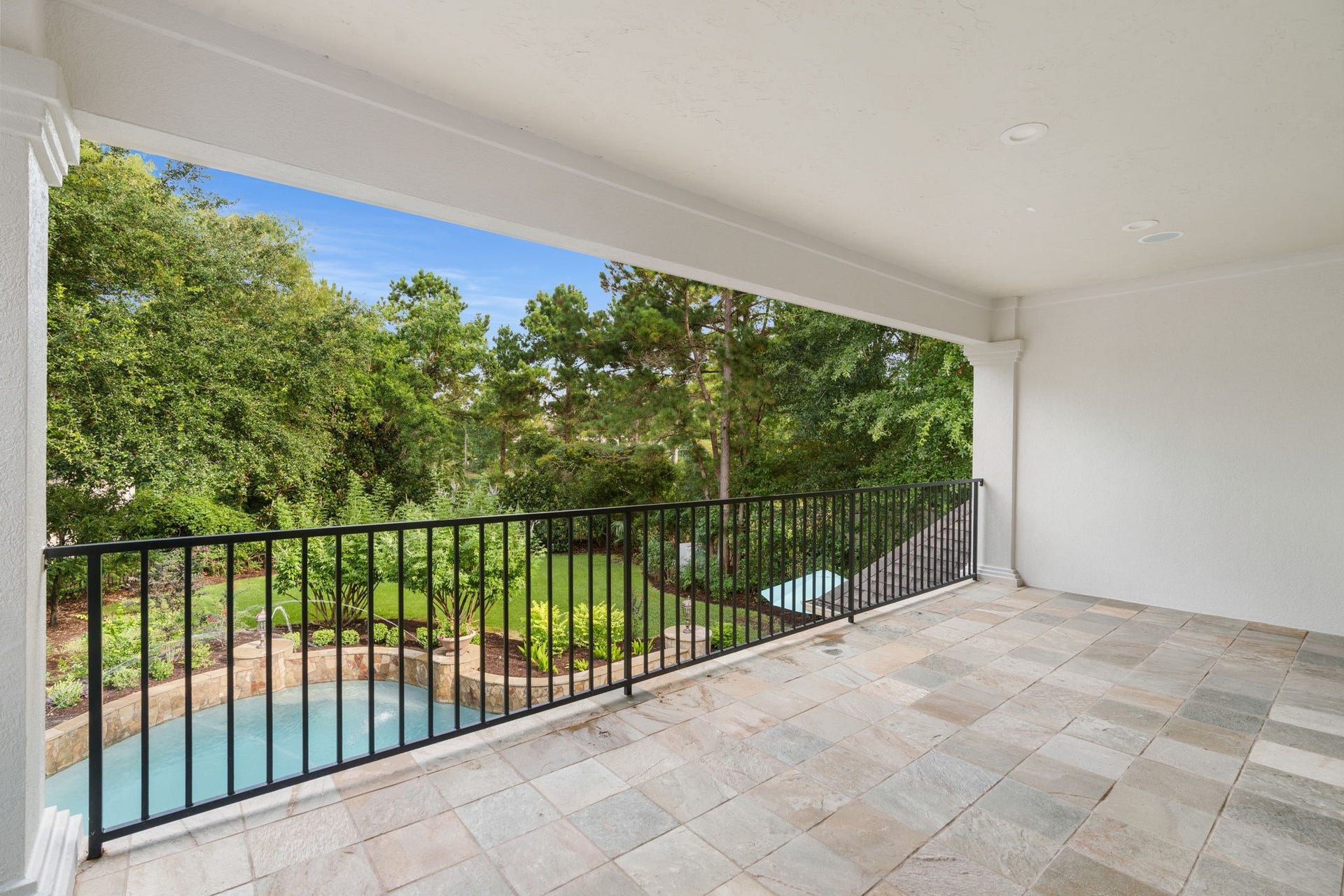 39 N Palmiera Circle, The Woodlands, TX 77382 Oversized balcony extends the entertaining or relaxing space of this amazing property. The privacy from mature trees combined with the pool sightline gives it a resort feel without ever leaving the porch.