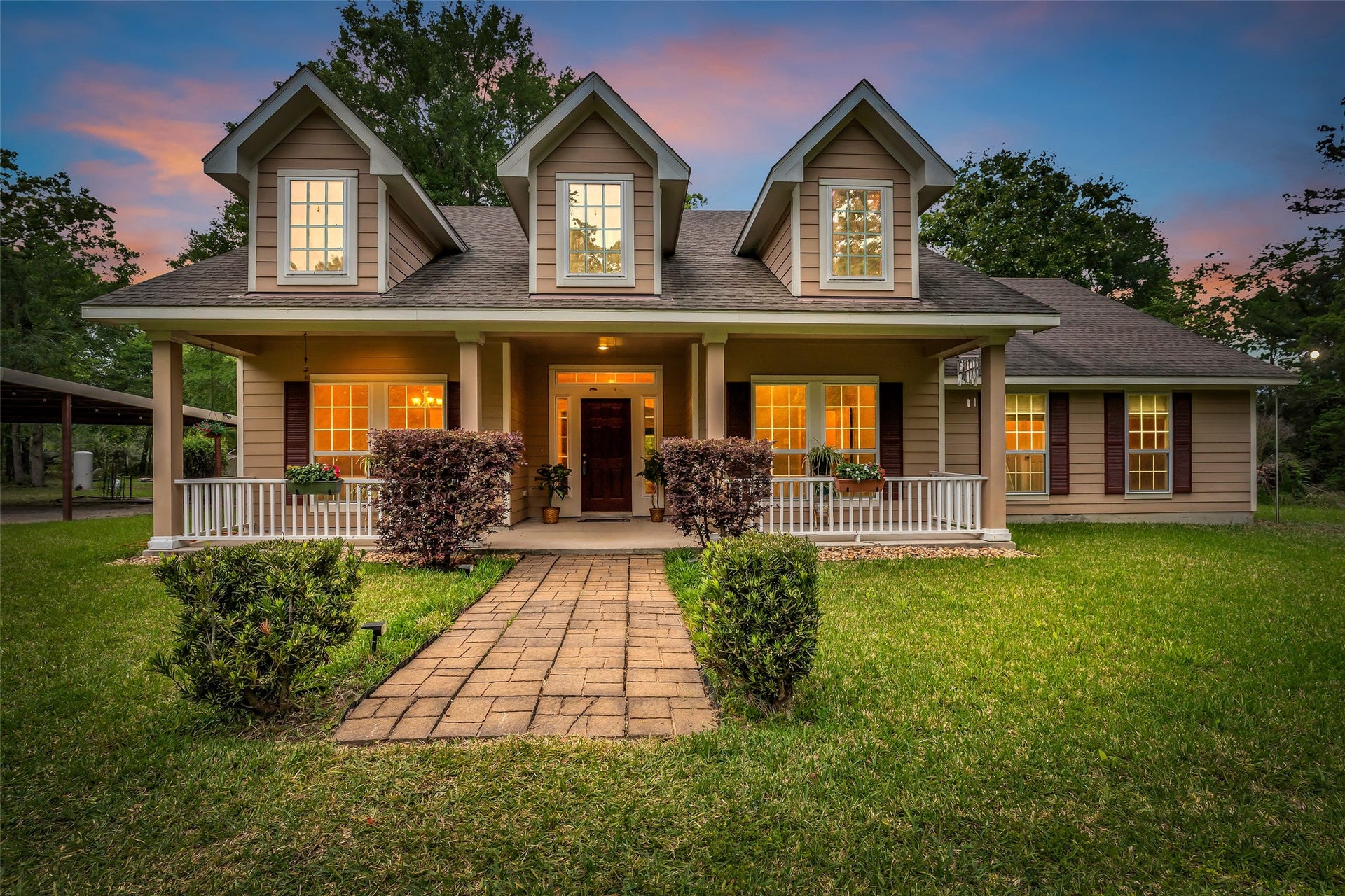 27527 Tepee Trail, Hockley, TX 77447 A welcoming home with porch and beautifully landscaped yard, set against a picturesque sunset backdrop.