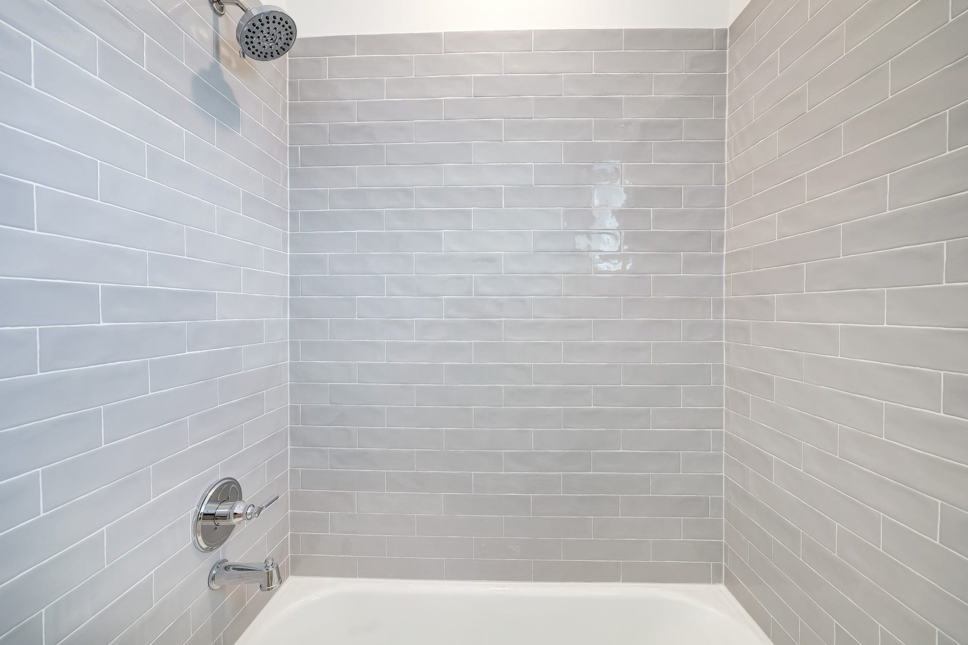 9311 Montridge Drive, Houston, TX 77080 Modern bathroom with sleek subway tiles and a luxurious rainfall showerhead, creating a serene spa-like experience.