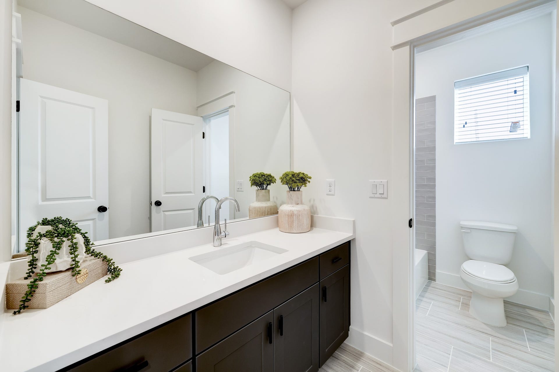 9311 Montridge Drive, Houston, TX 77080 Modern Elegance: This bathroom boasts sleek fixtures, dual vanities, and a spacious walk-in shower, all adorned with contemporary finishes for a serene retreat.