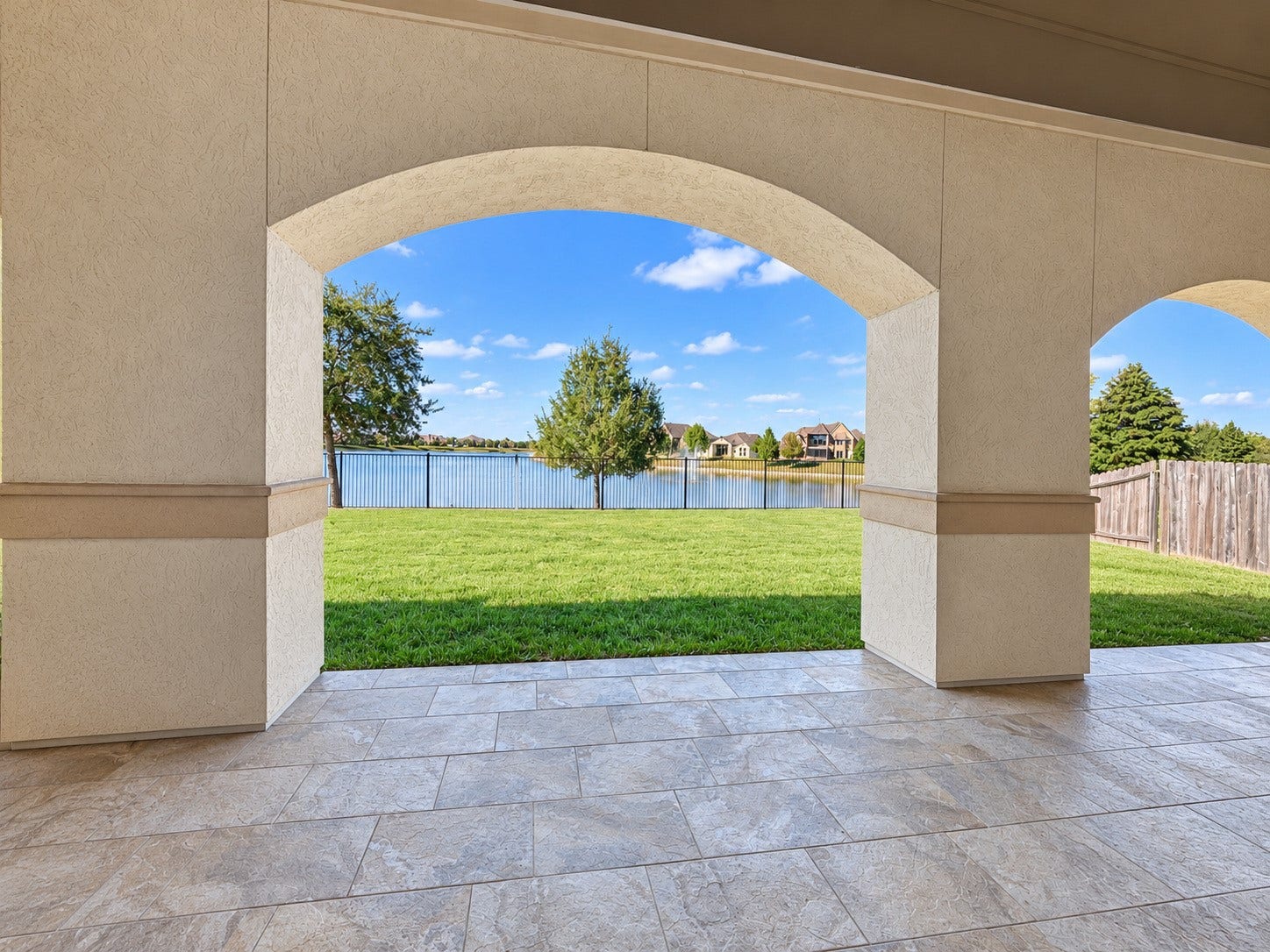 3414 Magnolia Shores Lane, Pearland, TX 77584 Inviting covered patio featuring arched openings and peaceful views of the backyard and lake.