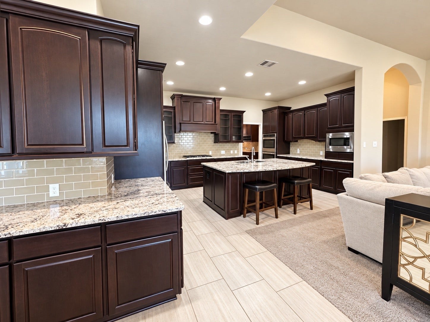 3414 Magnolia Shores Lane, Pearland, TX 77584 Convenient butler's pantry or serving area featuring rich dark cabinetry, granite countertops, and attractive tile backsplash.
