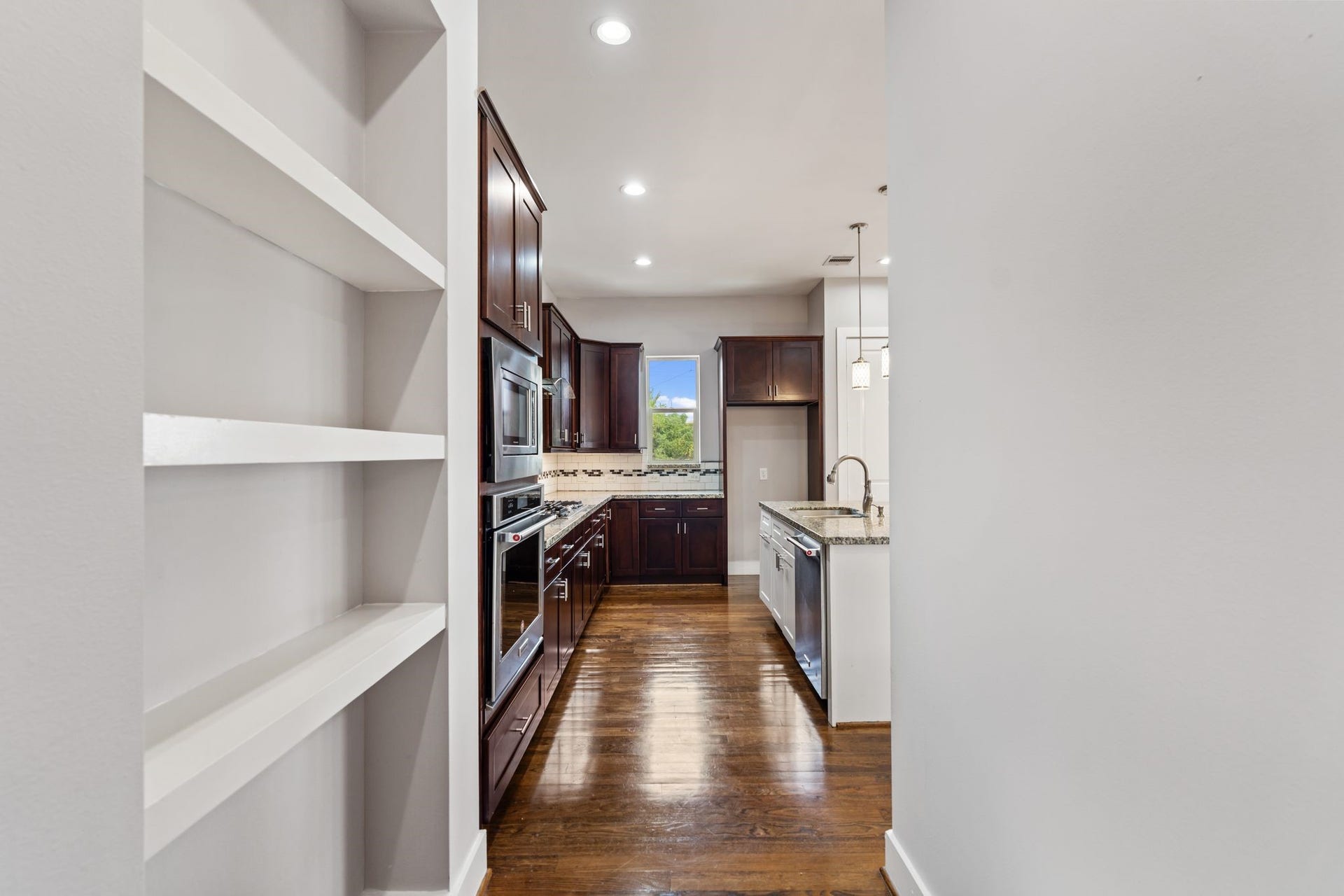 1005 Bingham Street, #5, Houston, TX 77007 Second-floor landing leading into the kitchen and open living space, with built-in shelving.