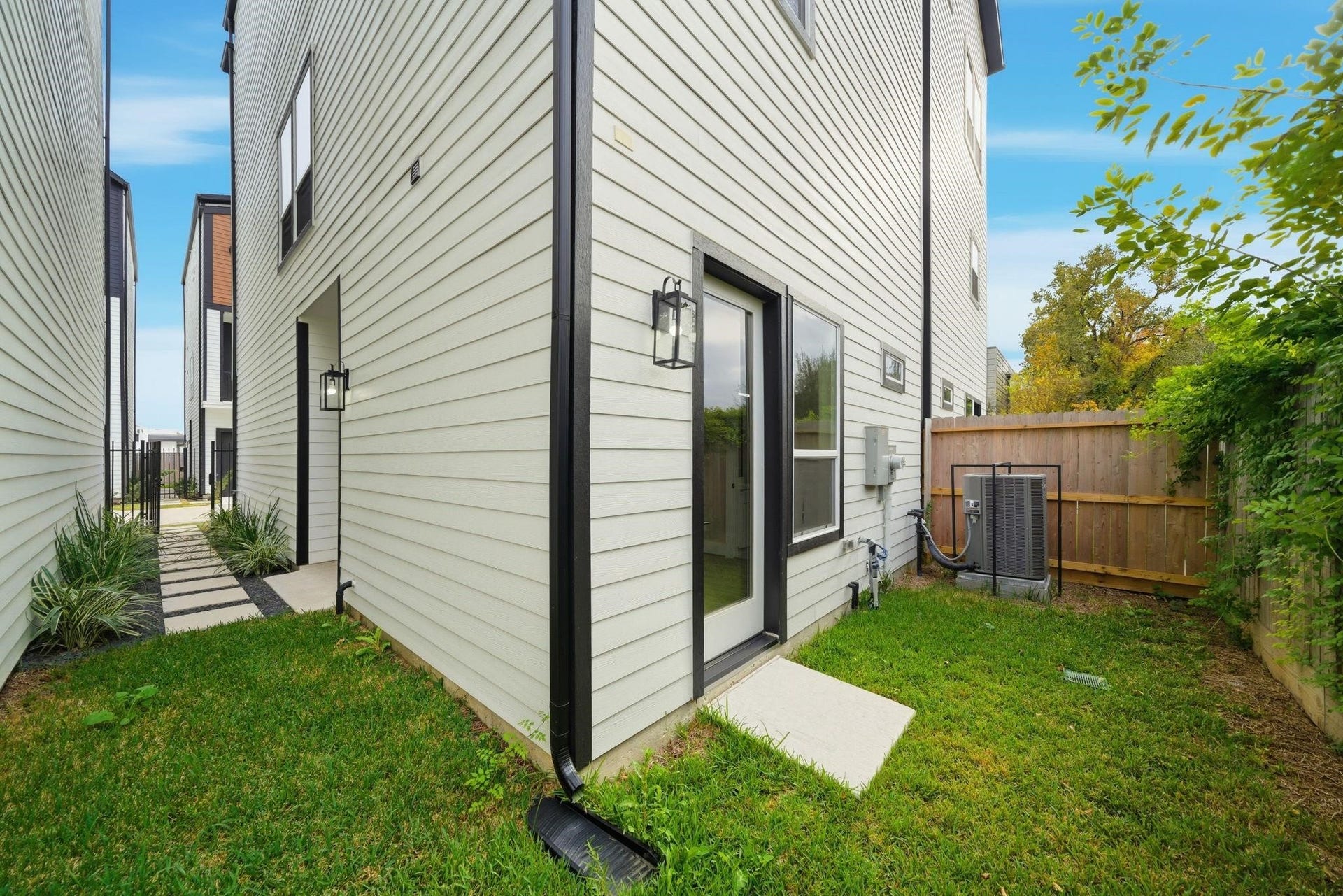 4013 Griggs Road, #F, Houston, TX 77021 Modern side yard with a fenced area, featuring sleek exterior lighting and well-maintained greenery, offering a private outdoor space.