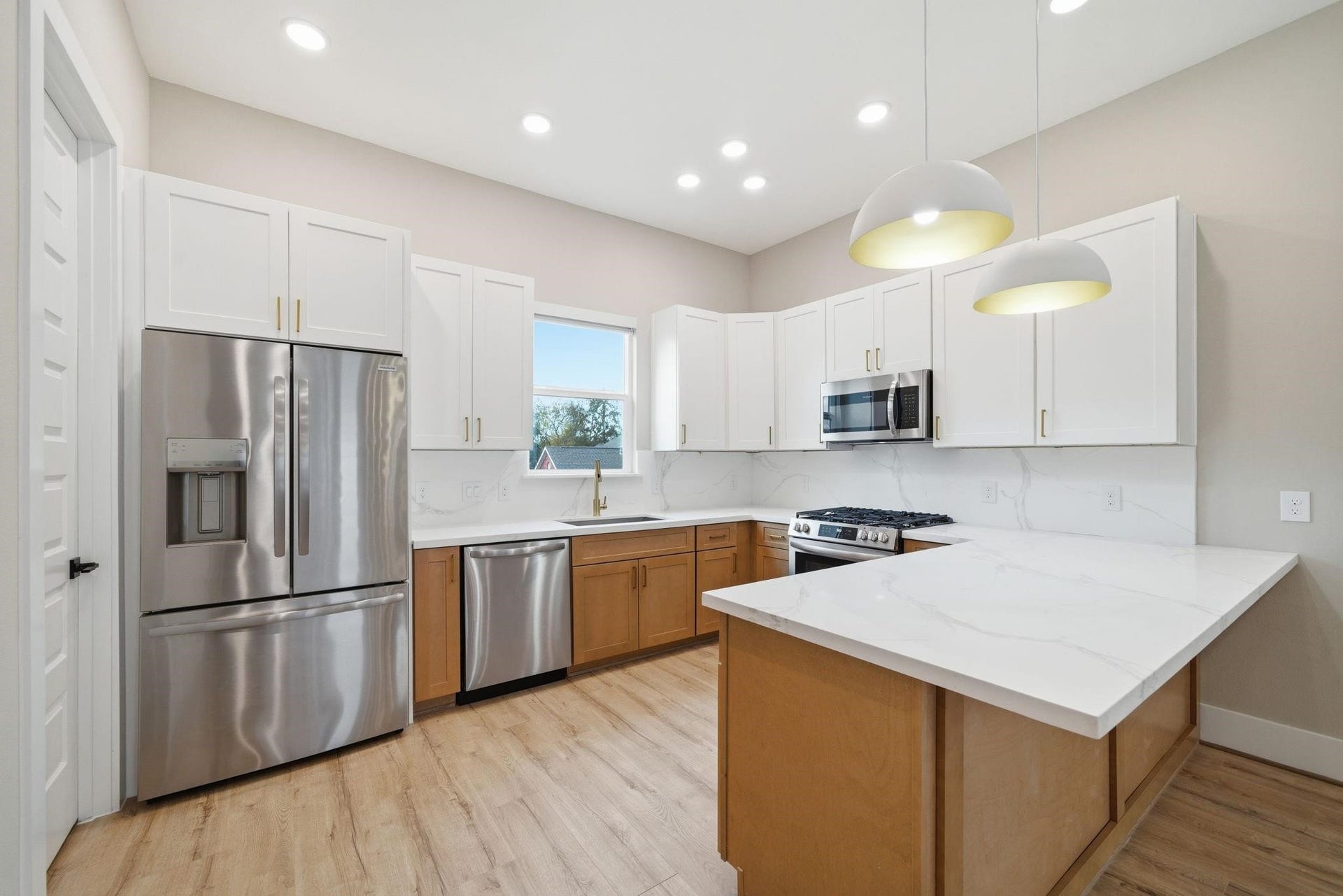 4013 Griggs Road, #F, Houston, TX 77021 Bright and modern kitchen featuring sleek stainless steel appliances, elegant white cabinetry with contrasting wood accents, and a spacious marble countertop perfect for meal prep and entertaining.