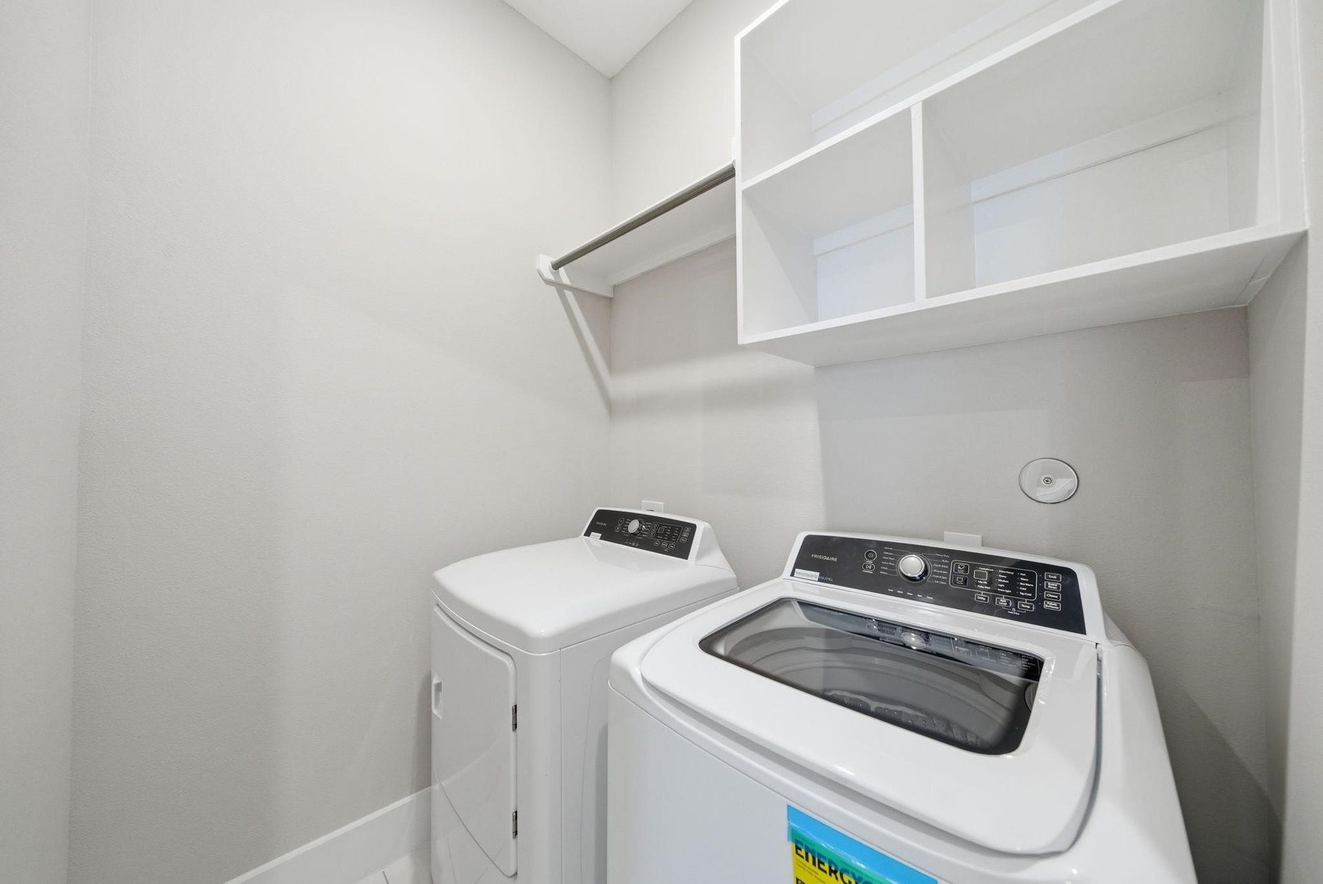 4013 Griggs Road, #F, Houston, TX 77021 Modern laundry room featuring a sleek washer and dryer set, ample shelving, and a convenient hanging rod for easy organization.