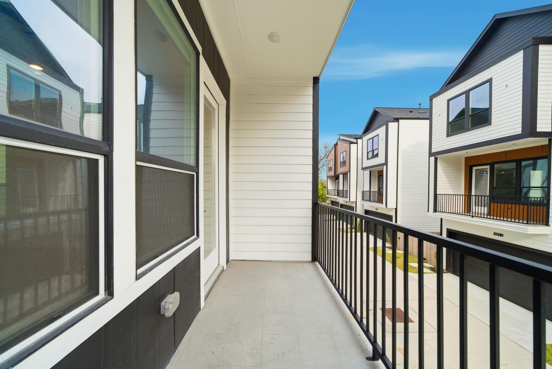 4013 Griggs Road, #F, Houston, TX 77021 Charming balcony with modern railing offers a cozy outdoor space overlooking a contemporary neighborhood.