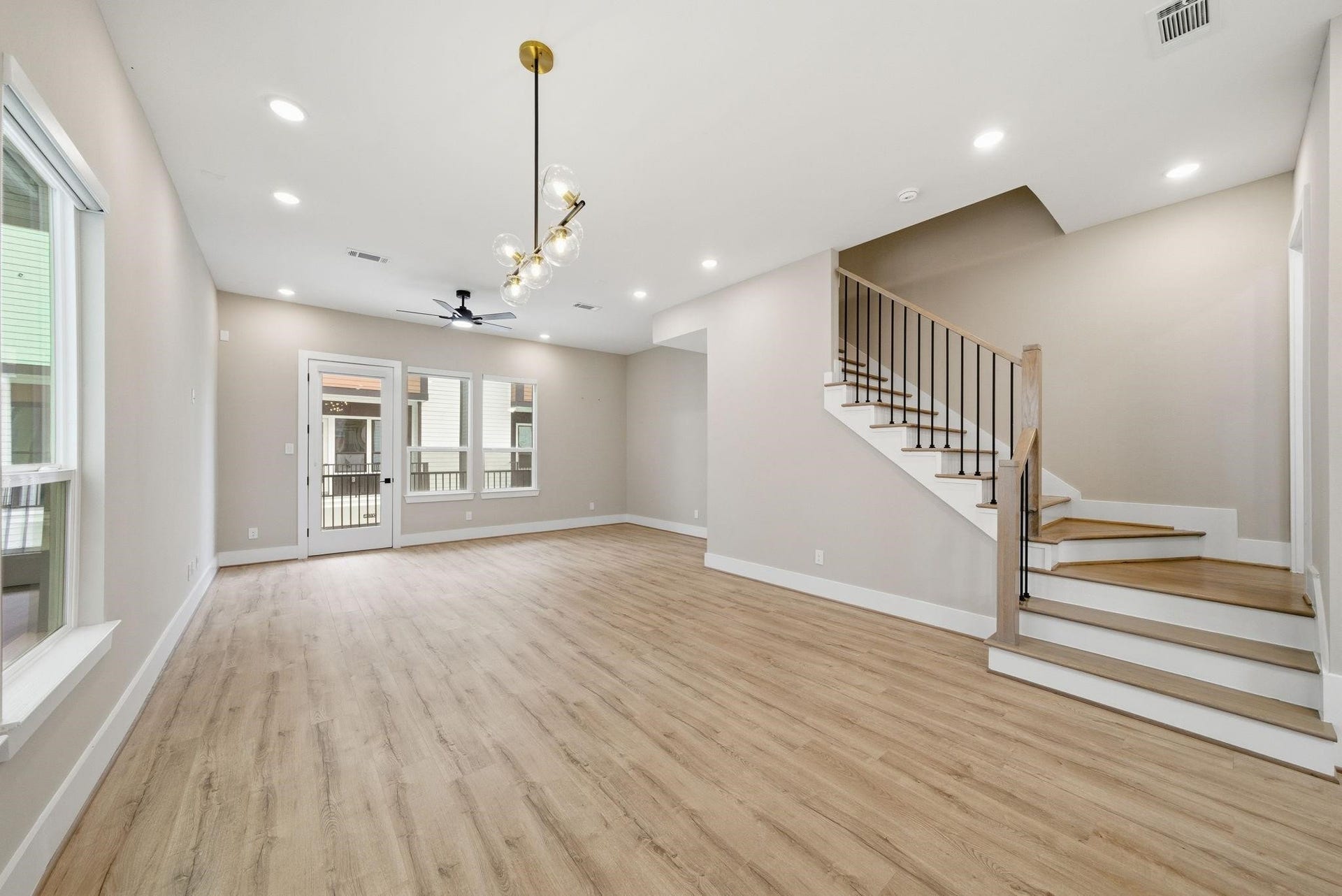 4013 Griggs Road, #F, Houston, TX 77021 Spacious open-concept living area with elegant wood flooring, modern lighting, and a sleek staircase, leading to a bright and airy space perfect for entertaining.