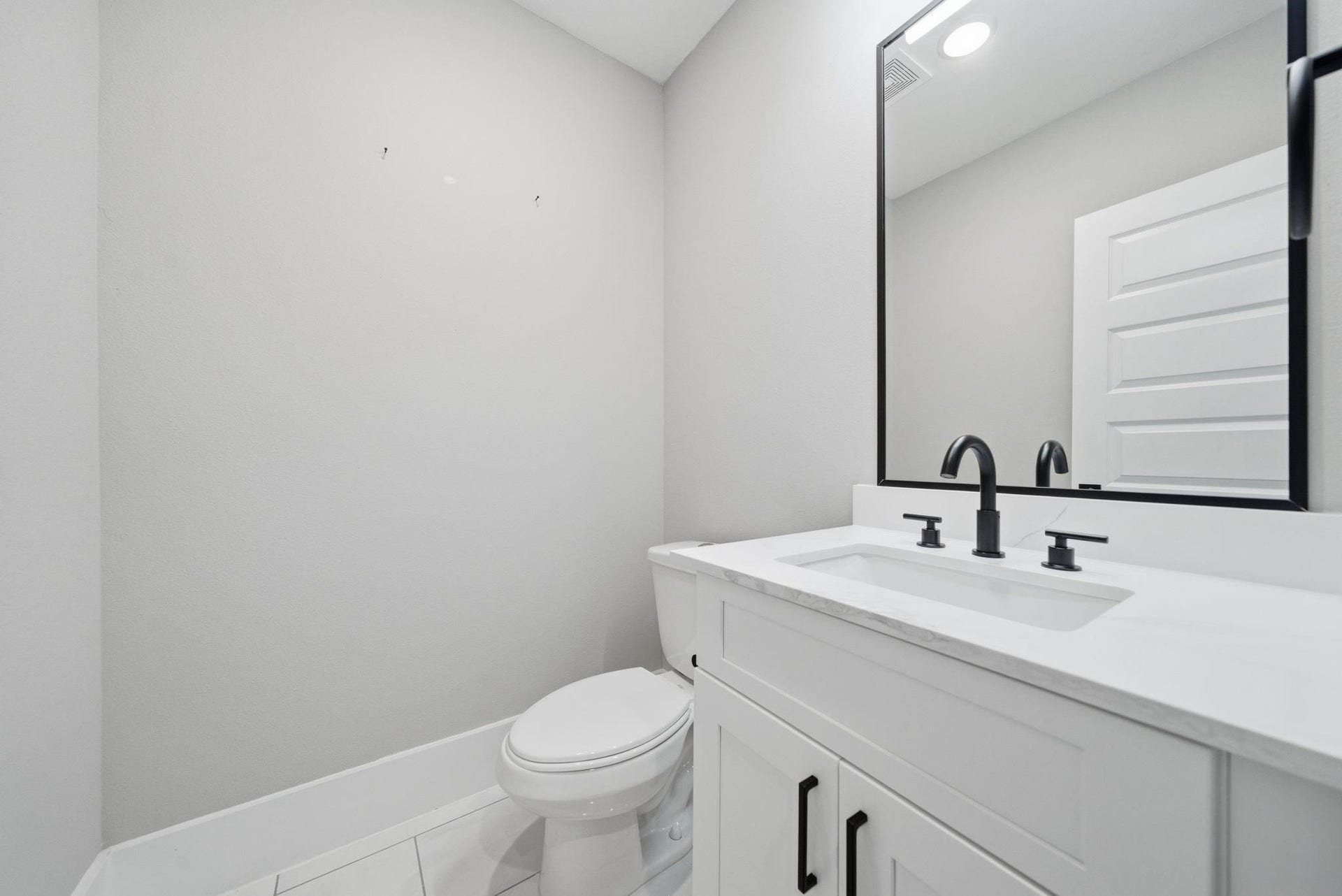 4013 Griggs Road, #F, Houston, TX 77021 Sleek and modern bathroom featuring a stylish vanity with dual faucets, a large framed mirror, and contemporary fixtures.