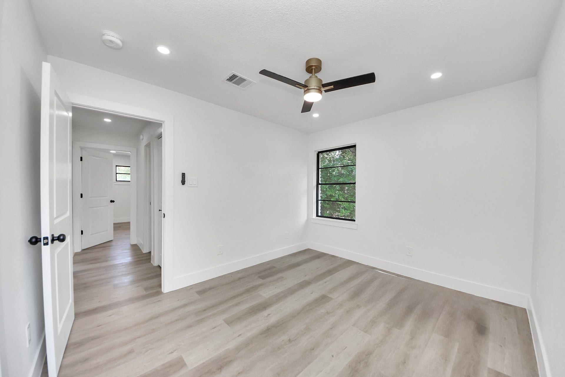 602 Gammon Drive, Houston, TX 77022 Bright and airy bedroom featuring sleek hardwood floors, a modern ceiling fan, and ample natural light from the window.