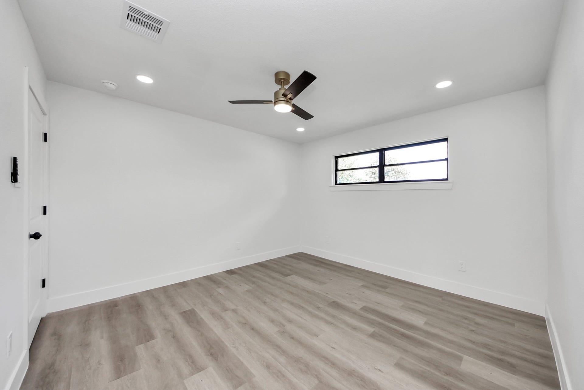 602 Gammon Drive, Houston, TX 77022 Spacious bedroom with sleek wood flooring, contemporary ceiling fan, and a large window offering ample natural light.