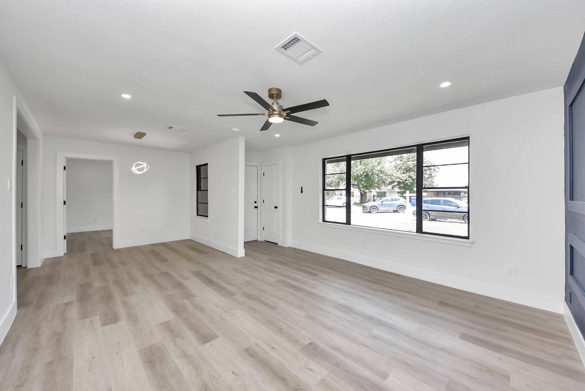 602 Gammon Drive, Houston, TX 77022 Bright and spacious living area with sleek laminate flooring, modern ceiling fan, and large windows offering abundant natural light.