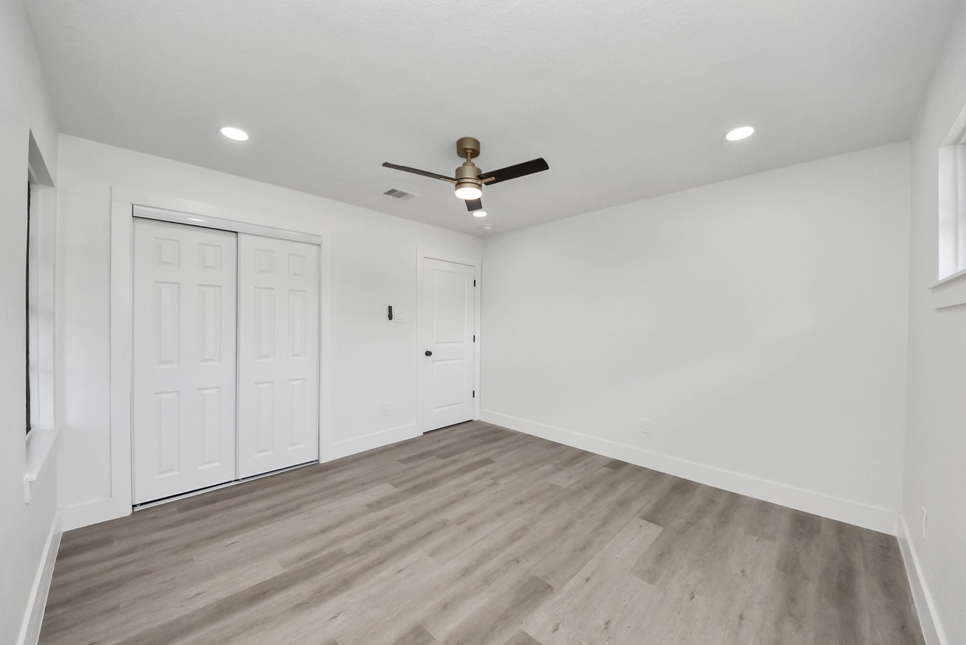 602 Gammon Drive, Houston, TX 77022 Bright and spacious room featuring modern recessed lighting, sleek ceiling fan, and stylish wood-look flooring, complemented by a large closet with sliding doors.