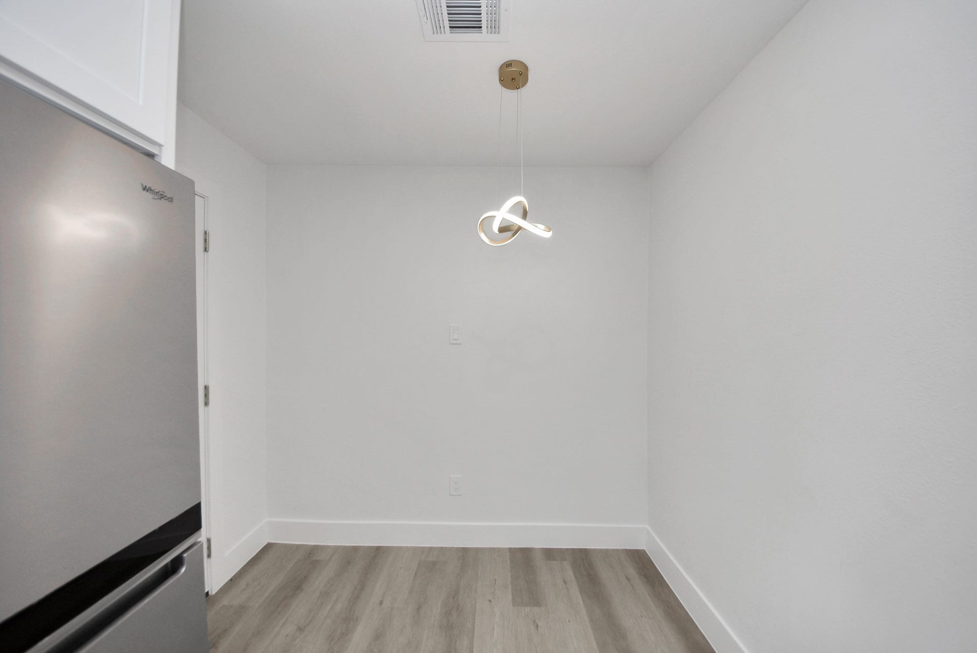602 Gammon Drive, Houston, TX 77022 Chic and minimal dining area featuring modern light fixtures, sleek stainless steel appliances, and elegant wood flooring.