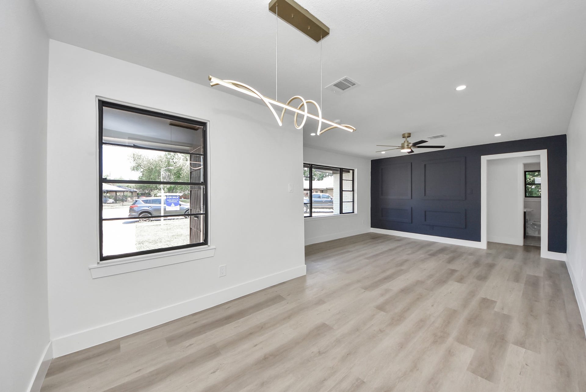 602 Gammon Drive, Houston, TX 77022 Spacious living area with modern lighting, sleek wood flooring, and a stylish accent wall, offering a contemporary and inviting atmosphere.