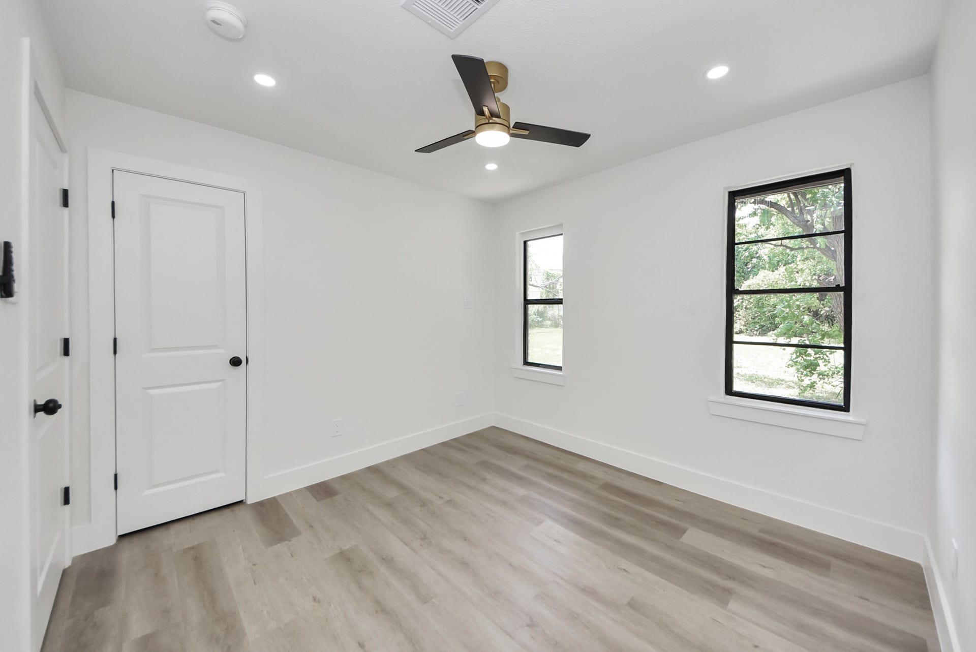 602 Gammon Drive, Houston, TX 77022 Bright and airy room featuring sleek hardwood floors, modern ceiling fan, and large windows offering abundant natural light.