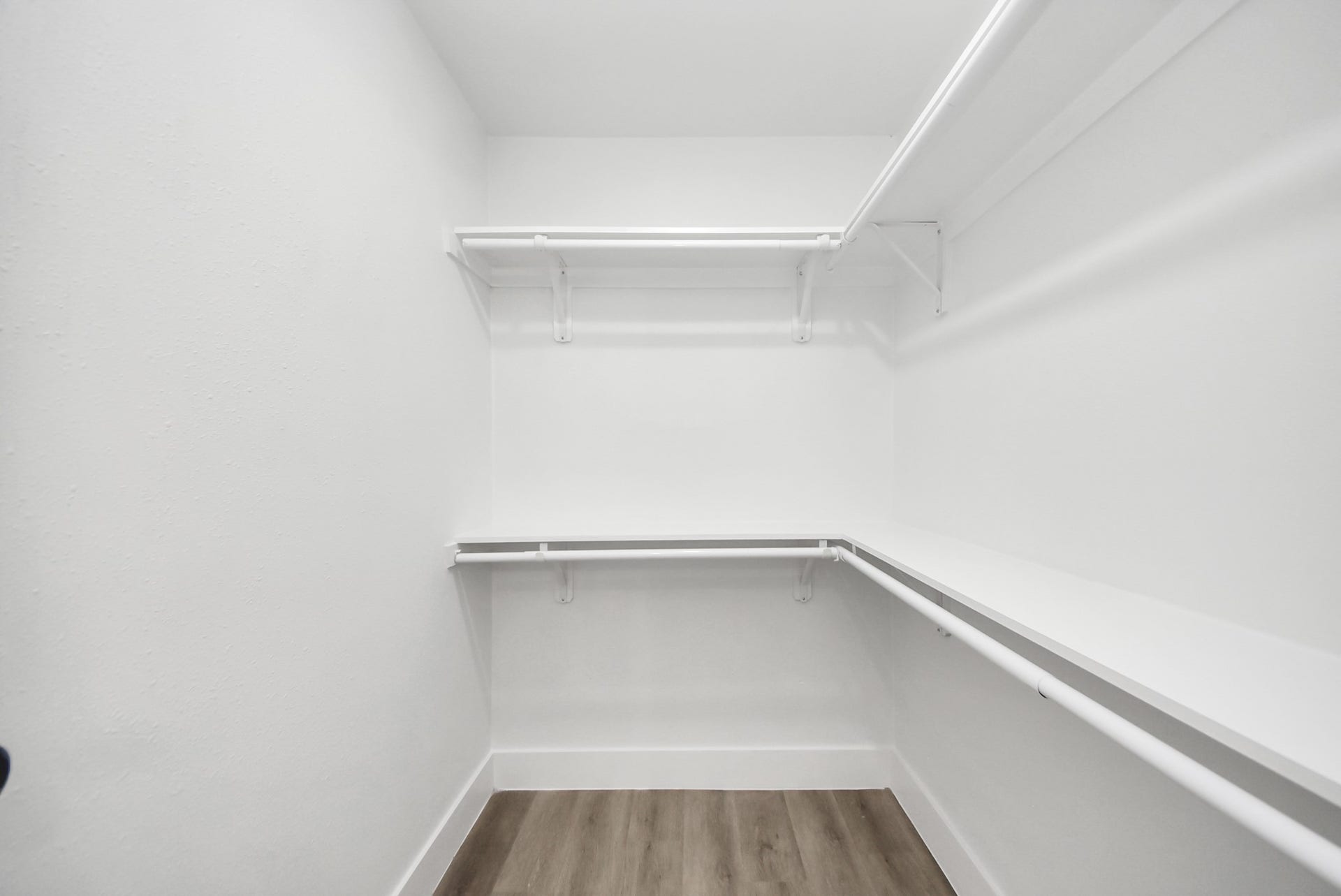 602 Gammon Drive, Houston, TX 77022 Spacious walk-in closet with ample shelving and hanging space, featuring a modern, clean design and elegant wood flooring.