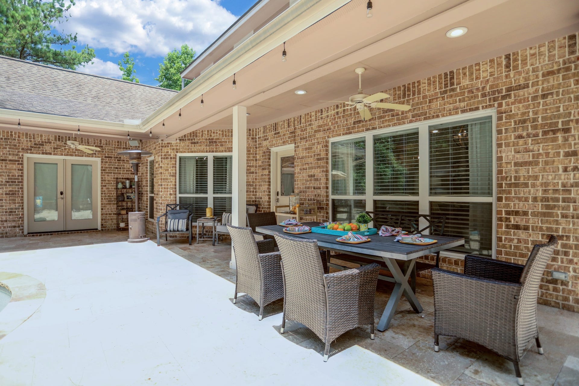 Covered patio space for having outdoor meals, ceiling fans, twinkling lights, and incredible pool vibes.