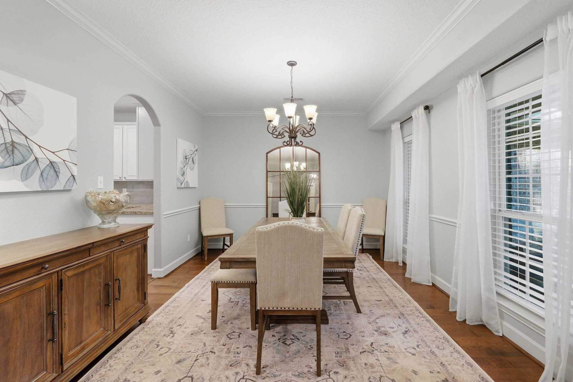 Another view of the formal dining room with arched doorways into the kitchen.  Beautiful hardwood floors, neutral recent painting.