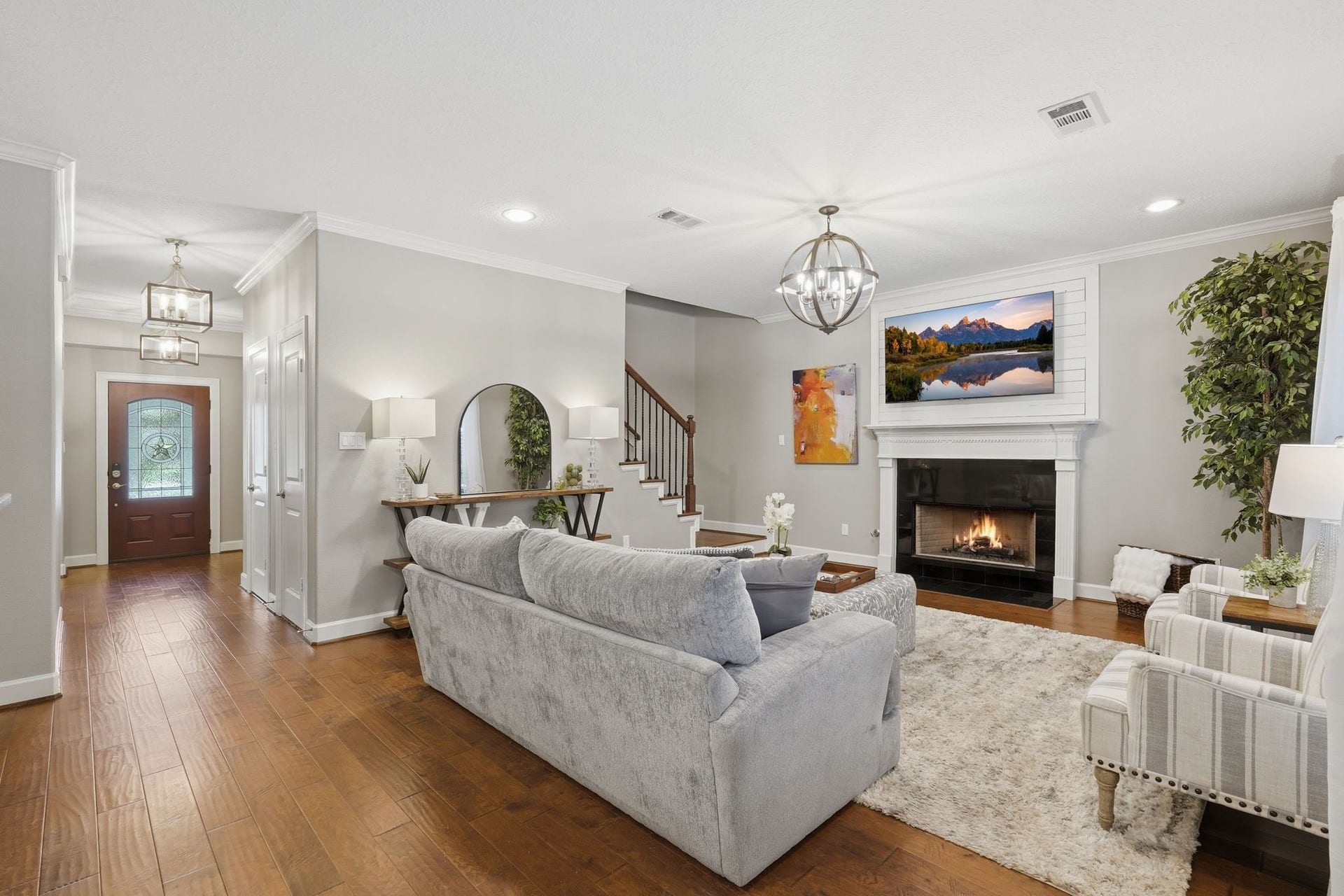 Open concept family room with gas fireplace, beautiful pool views, hardwood floors, upgraded lights, shows like a model home.