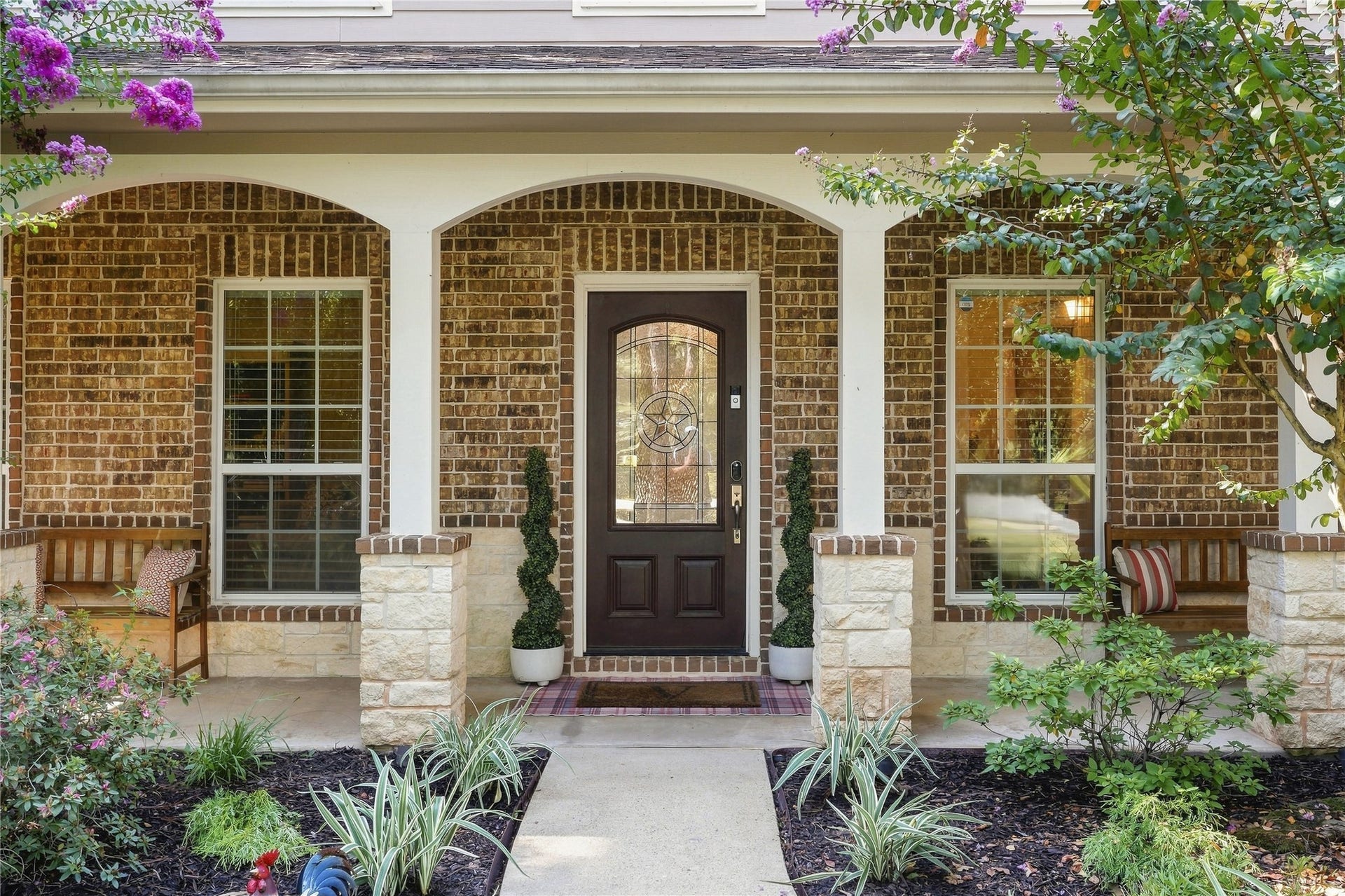 Beautiful front fascia with southern covered porch and beautiful front walk with beautiful landscaping.