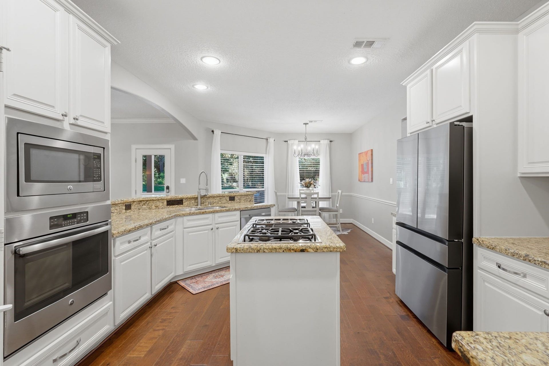 Granite and stainless kitchen, island with gas cooktop, stainless fridge included, convection oven, built-in microwave, and a nice walk-in pantry with a doorway into the formal dining room.