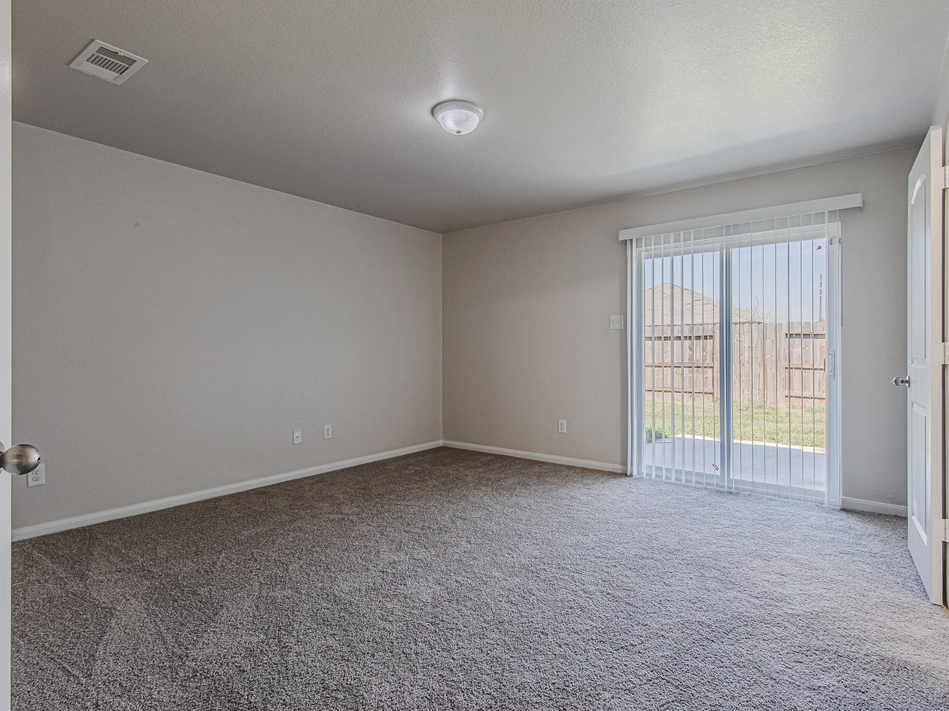 1223 Emerald Stone Drive, Rosharon, TX 77583 The primary bedroom offers comfortable proportions, carpet flooring, a ceiling fan, and windows overlooking the backyard.