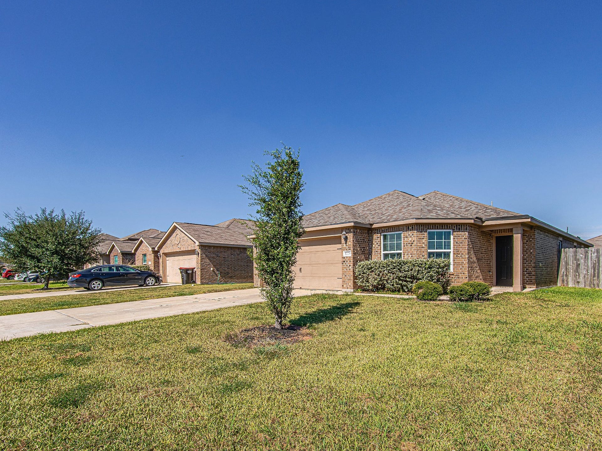 1223 Emerald Stone Drive, Rosharon, TX 77583 An alternate front view highlights the brick exterior, landscaped planting beds, and walkway leading to the covered entrance.