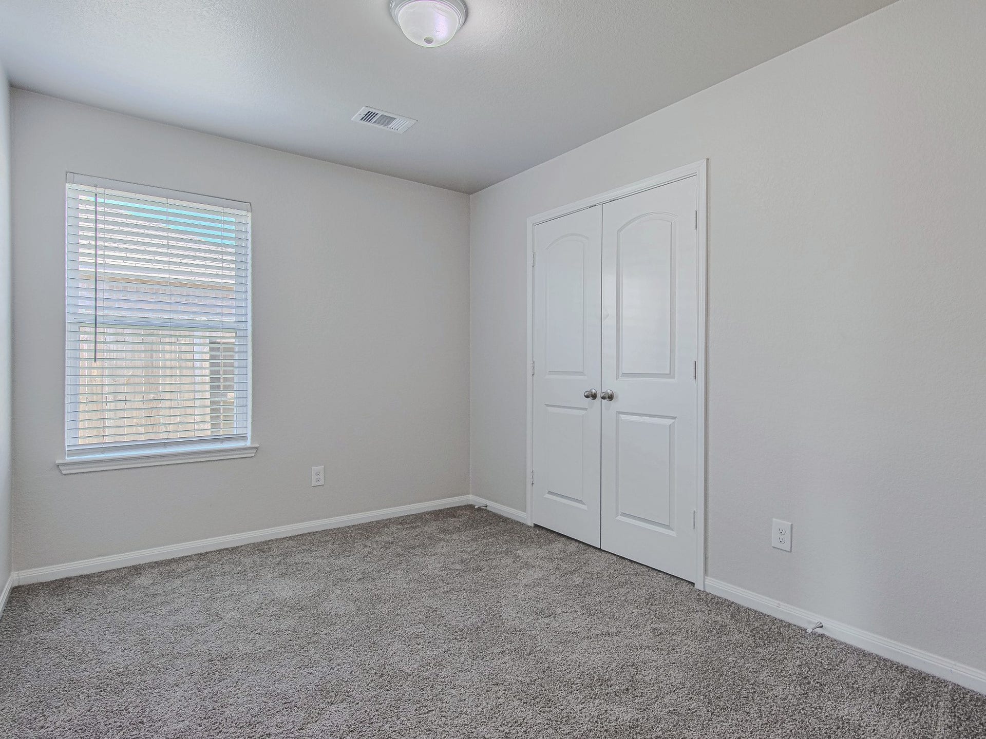 1223 Emerald Stone Drive, Rosharon, TX 77583 Another secondary bedroom offers carpet flooring, natural light, and closet storage, with room to personalize the space.