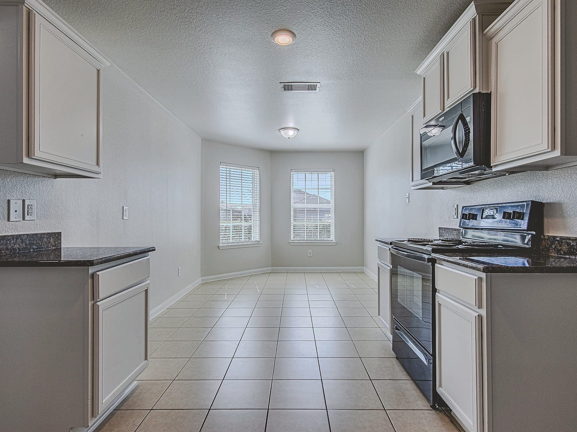 1223 Emerald Stone Drive, Rosharon, TX 77583 A view through the kitchen highlights its efficient layout and adjoining window-lined dining nook.