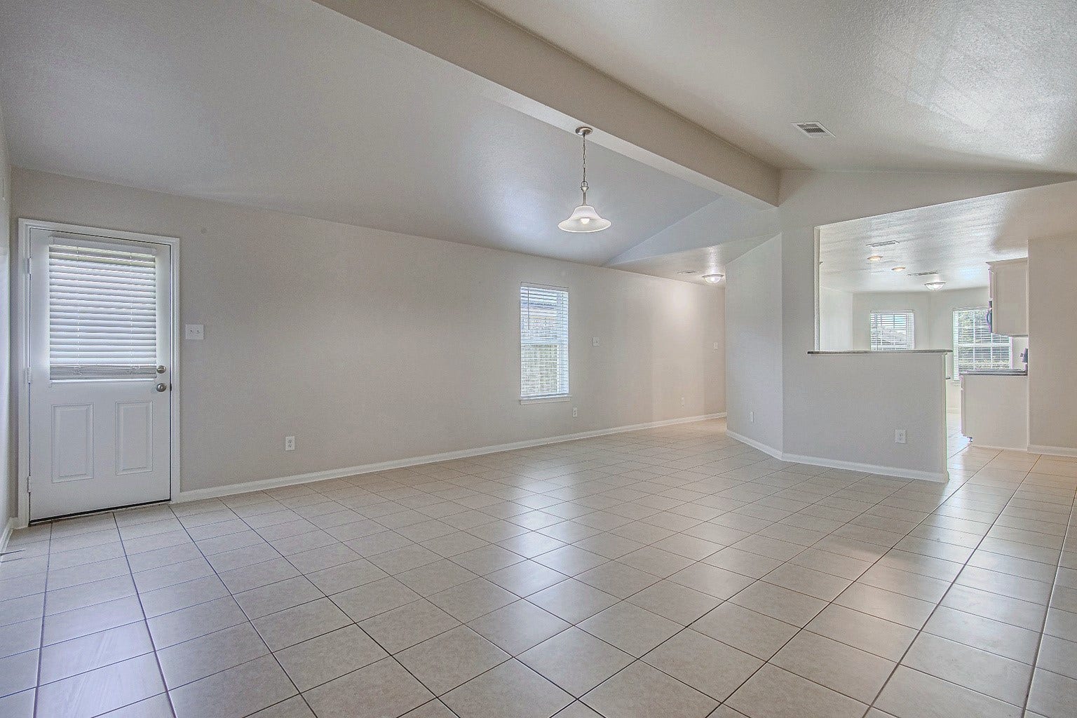 1223 Emerald Stone Drive, Rosharon, TX 77583 Natural light brightens this open living and dining area, complemented by tile flooring and neutral finishes that suit a variety of furnishings.