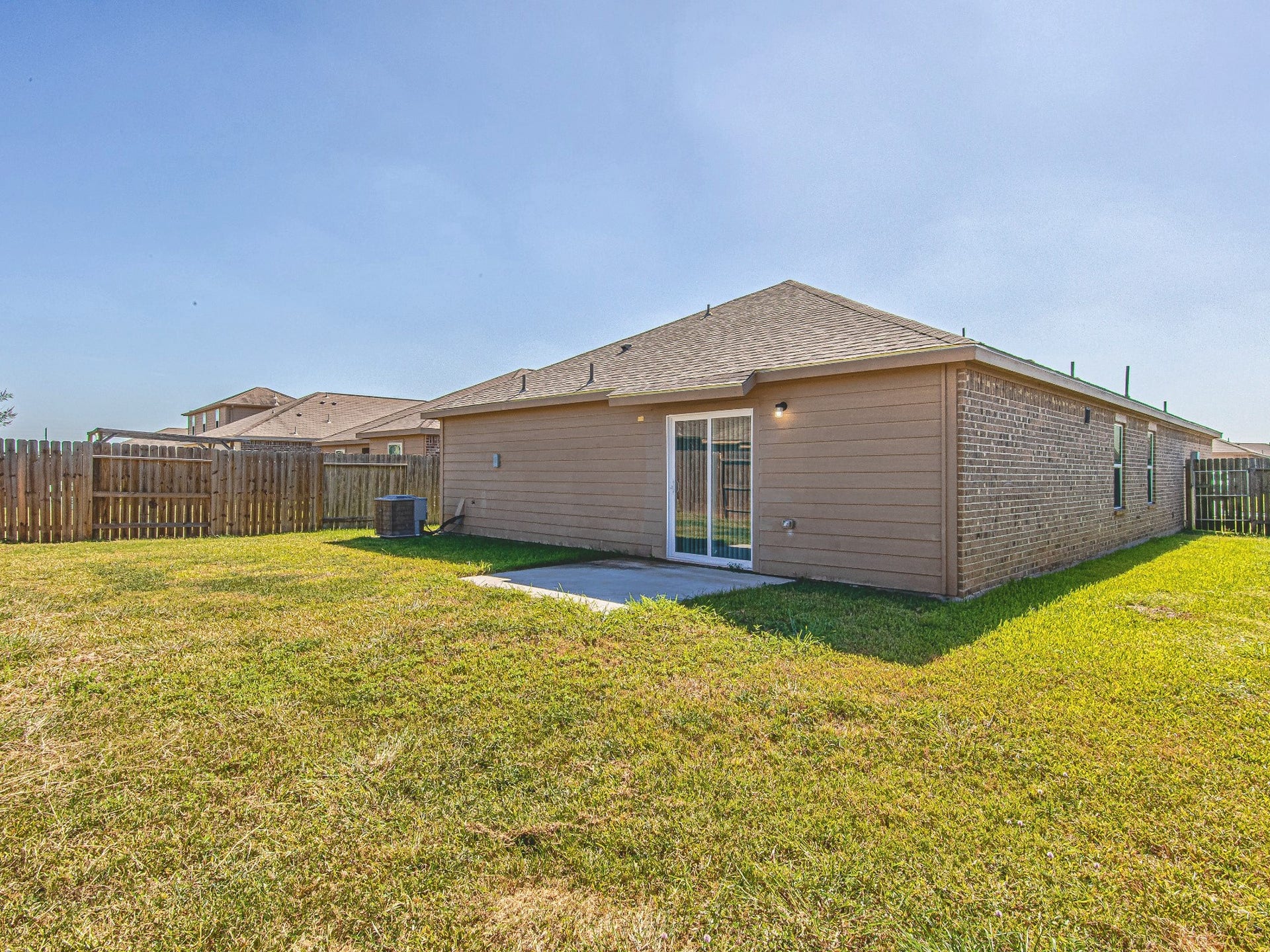 1223 Emerald Stone Drive, Rosharon, TX 77583 The rear exterior features direct backyard access and a concrete patio, with lawn space ready for your outdoor plans.