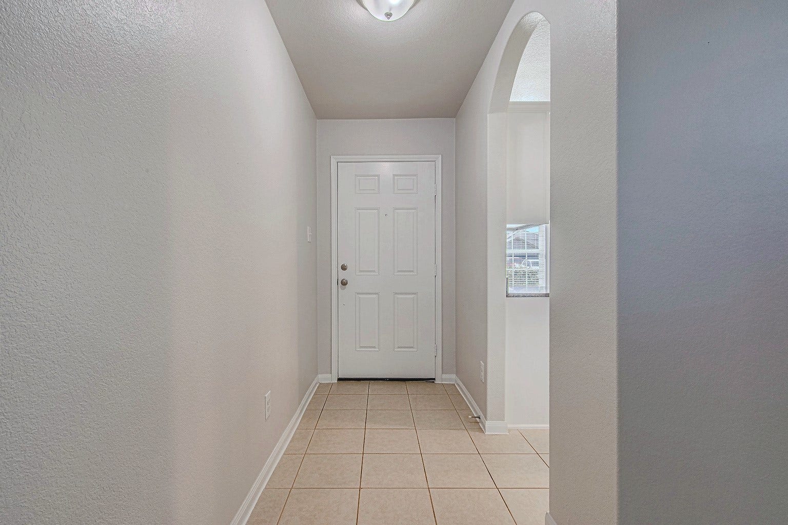 1223 Emerald Stone Drive, Rosharon, TX 77583 The tiled entry hallway offers a welcoming introduction to the home, with neutral walls and an easy-care floor.
