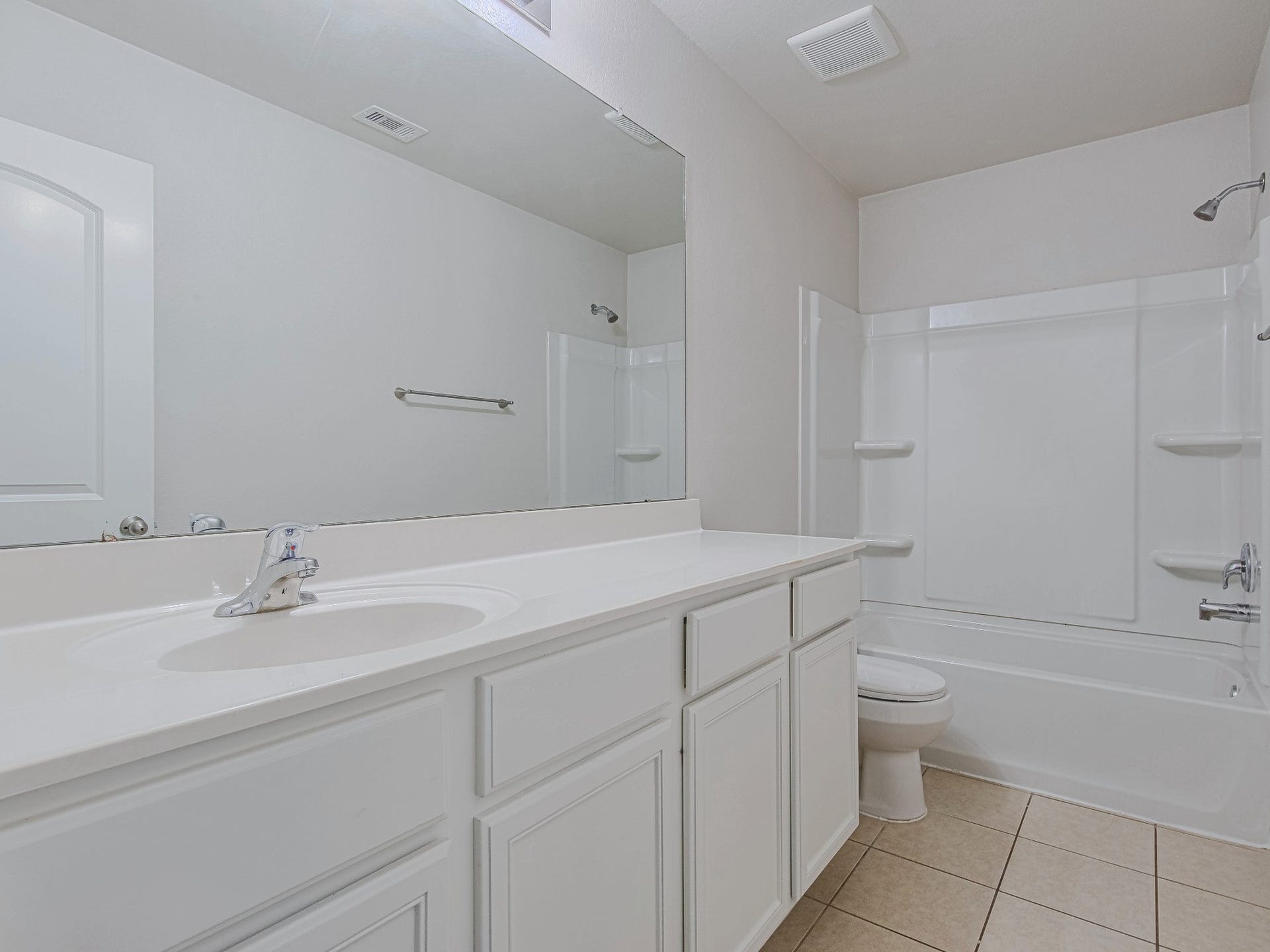 1223 Emerald Stone Drive, Rosharon, TX 77583 The secondary bathroom includes a vanity with cabinet storage, a wide mirror, and a tub-and-shower combination.