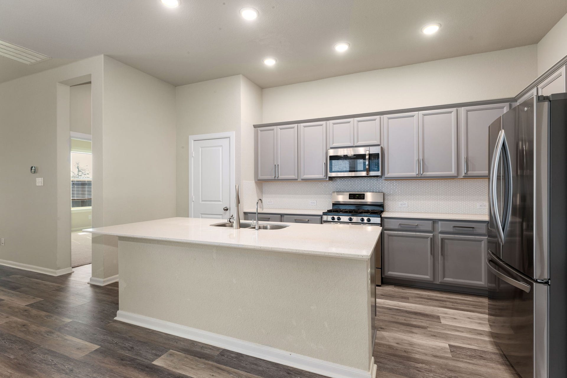 2715 Chestnut Oak Circle, Katy, TX 77494 Boasting grey cabinetry and sleek stainless steel appliances, this kitchen combines style and functionality.