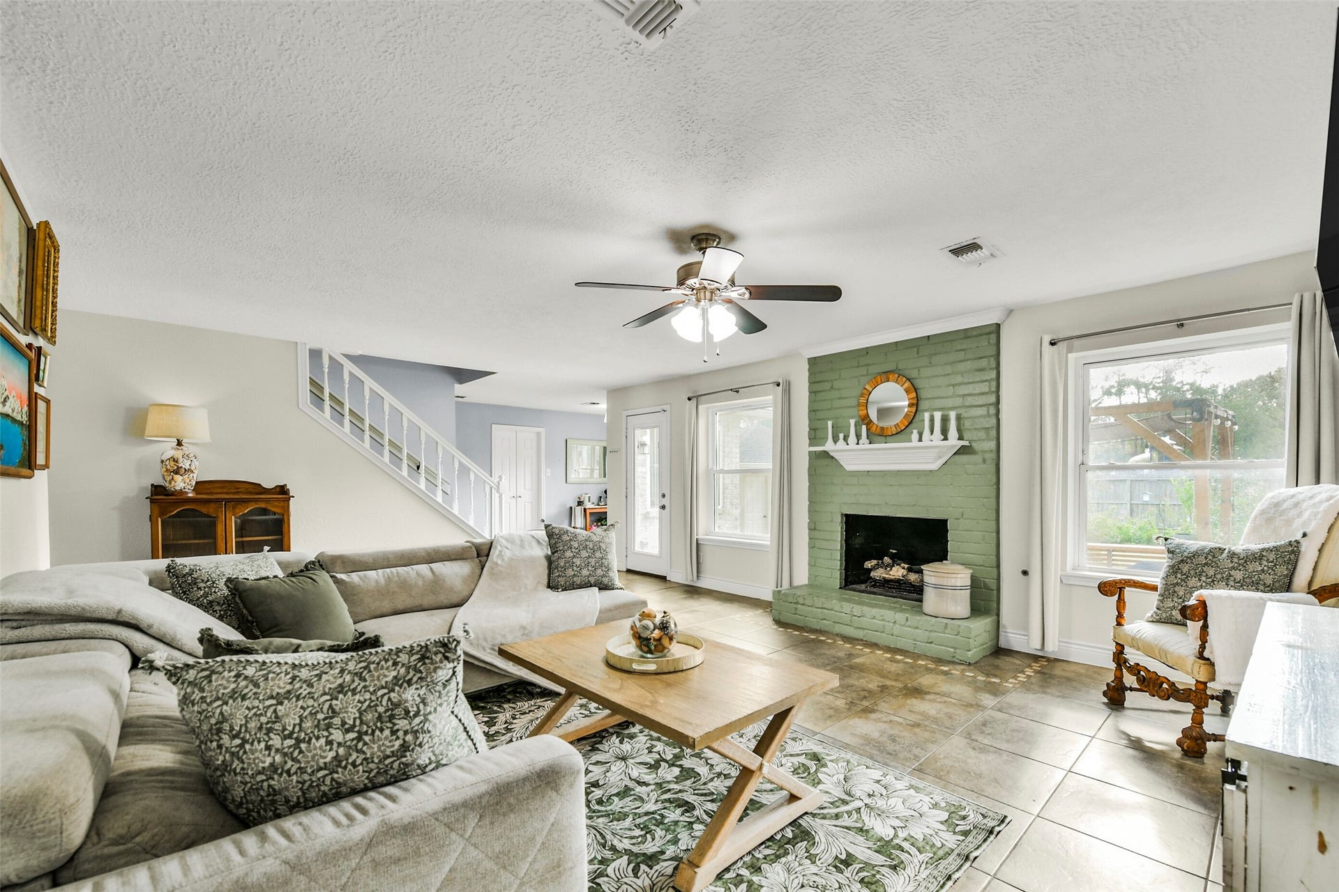 19611 Suncove Lane, Humble, TX 77346 A living room made for lingering. A painted brick fireplace adds personality and warmth, while generous windows brighten the spacious gathering areaan inviting setting for everything from quiet mornings to evenings with friends.