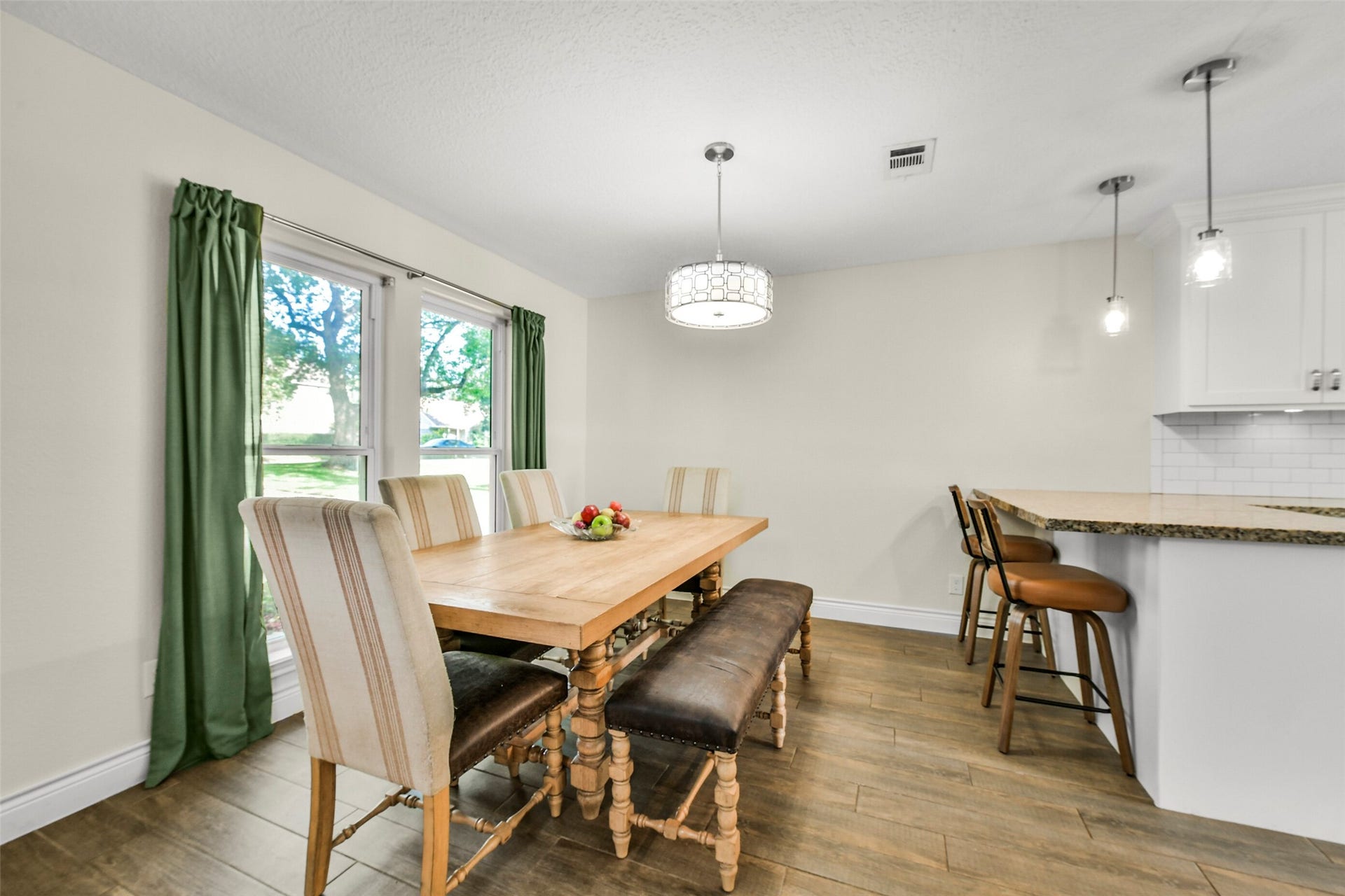 19611 Suncove Lane, Humble, TX 77346 Sunlight and garden views bring a relaxed feel to the dining area. With room to gather around the table and additional seating at the nearby breakfast bar, this space makes both casual meals and hosting feel effortless.