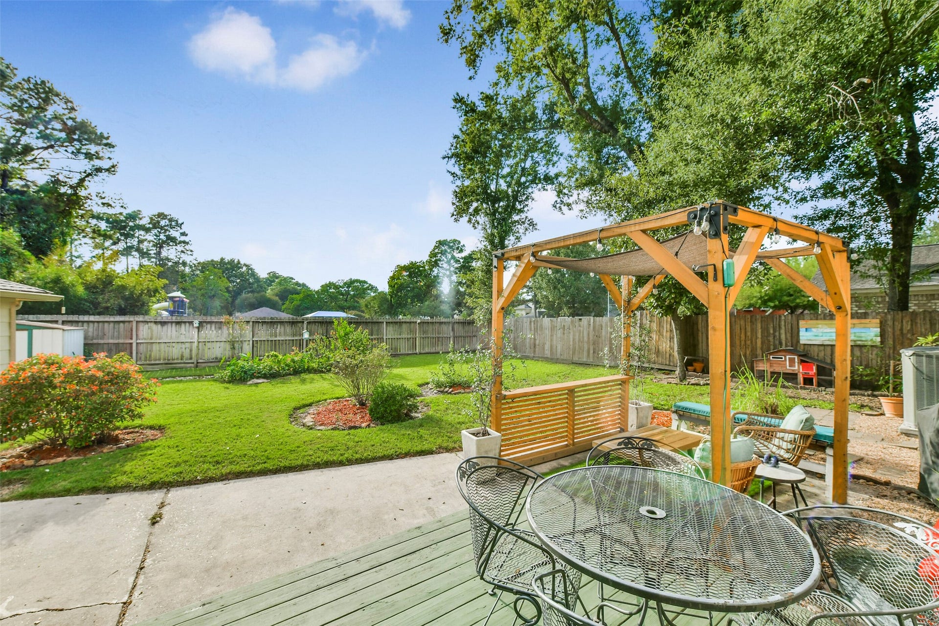 19611 Suncove Lane, Humble, TX 77346 Morning coffee, dinner outside or one more conversation before heading intheres a place for it all. The deck and adjoining patio offer multiple spots to gather, while a wood pergola with shade sails creates a cozy seating nook overlooking the lawn.