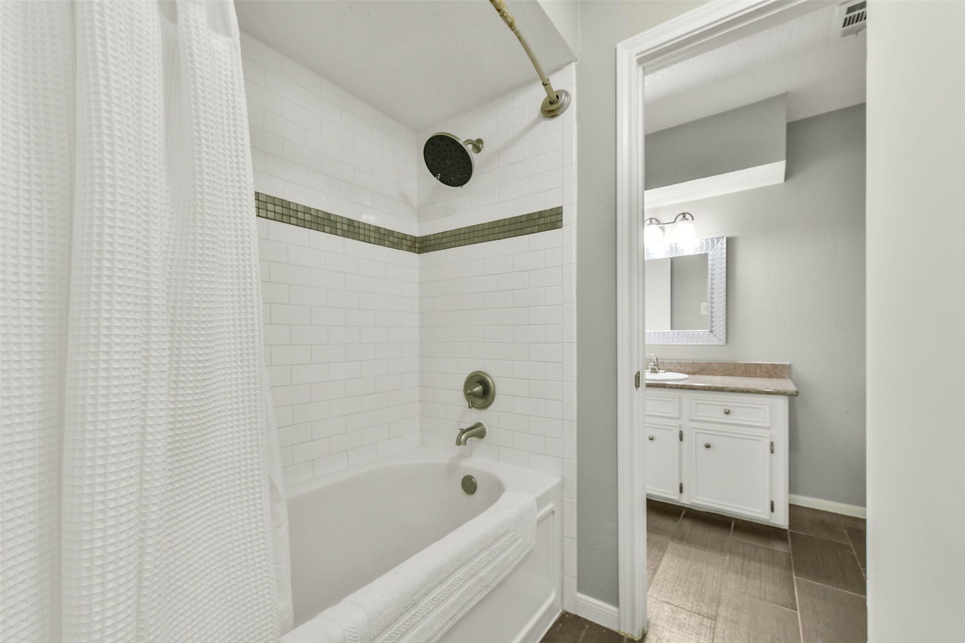 19611 Suncove Lane, Humble, TX 77346 Thoughtful vanity space makes busy routines a little easier. An extended countertop, white cabinetry and a decorative mirror bring together useful storage and a crisp, coordinated look.
