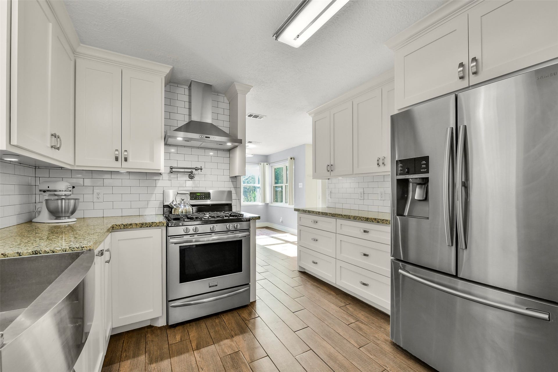 19611 Suncove Lane, Humble, TX 77346 A kitchen ready for everything from quick weeknight meals to a favorite weekend recipe. A gas range, stainless vent hood and ample cabinetry pair with a crisp subway-tile backsplash for a polished, cohesive look.