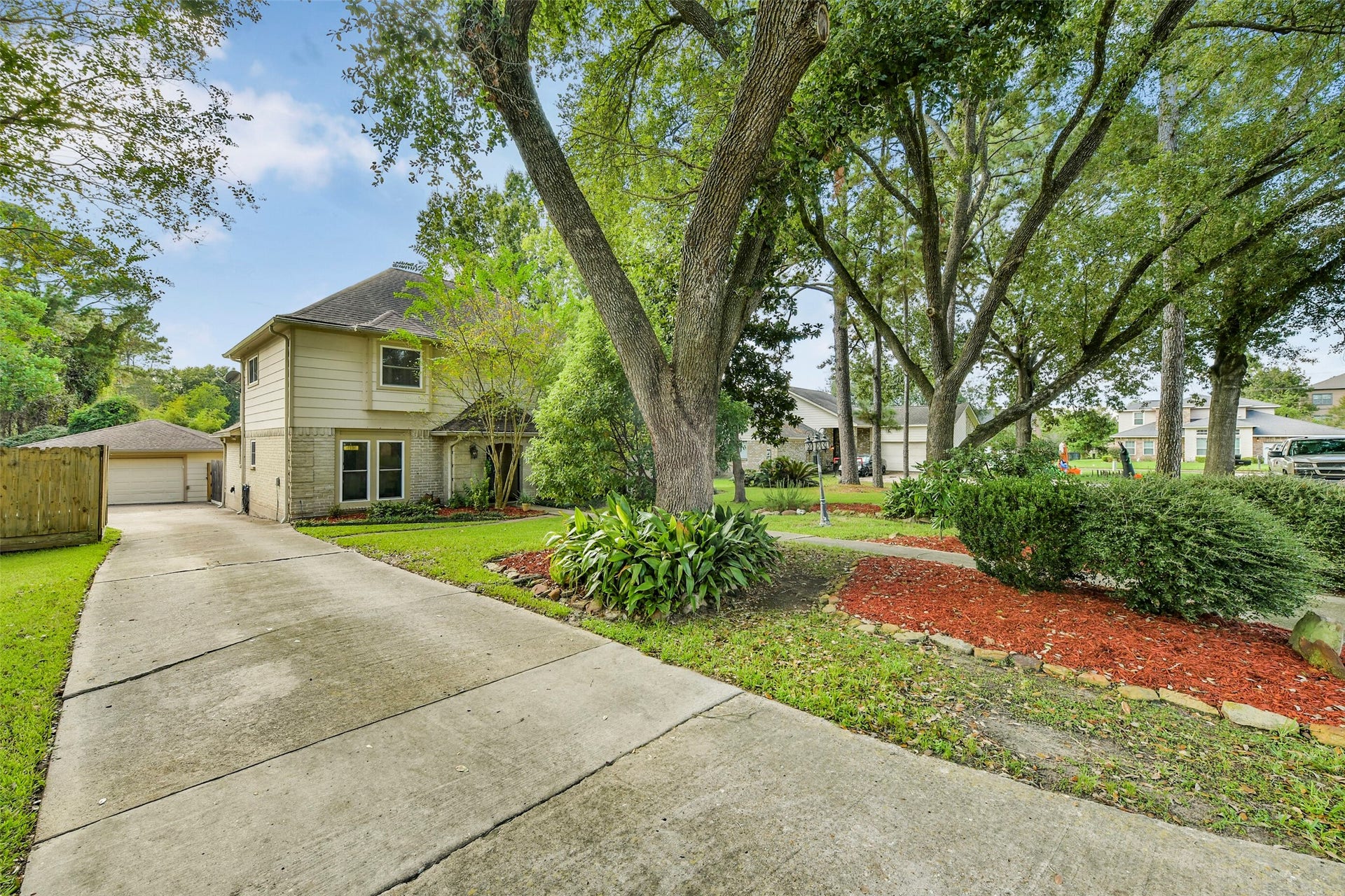 19611 Suncove Lane, Humble, TX 77346 An extended driveway leads to the garage positioned behind the home, leaving the front elevation free to shine. Mature trees and lush greenery make the approach feel just as inviting as the destination.