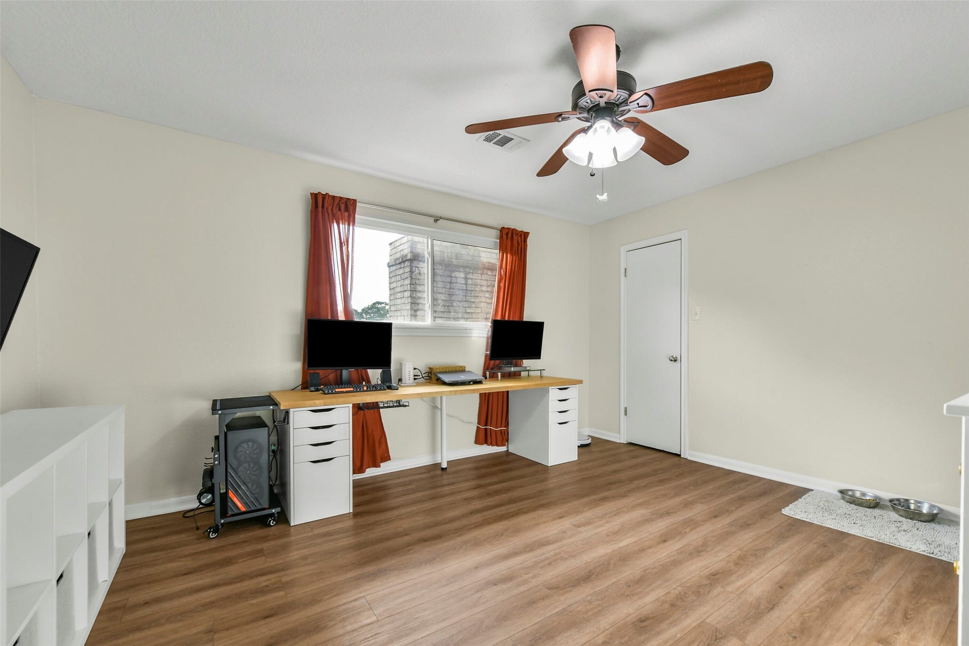 19611 Suncove Lane, Humble, TX 77346 Room for your next chapter. Currently styled as a home office, this versatile bedroom pairs natural light and warm wood-look flooring with closet storage, offering an inviting space for productive workdays, overnight guests or everyday relaxation.